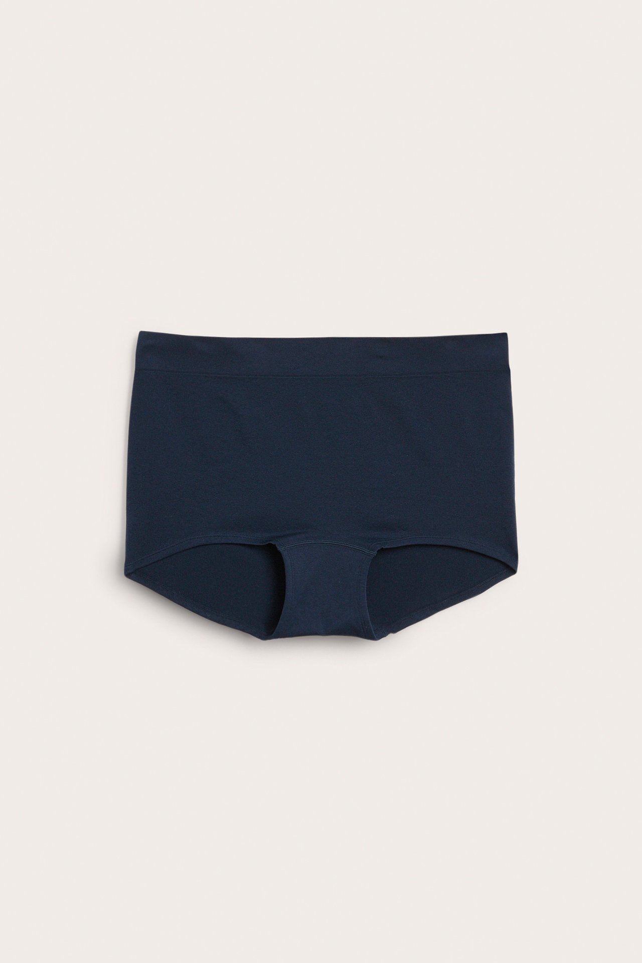 Frontvy av en mörkblå sömlös boxertrosa för dam, tillverkad av enfärgad polyamid och elastan.