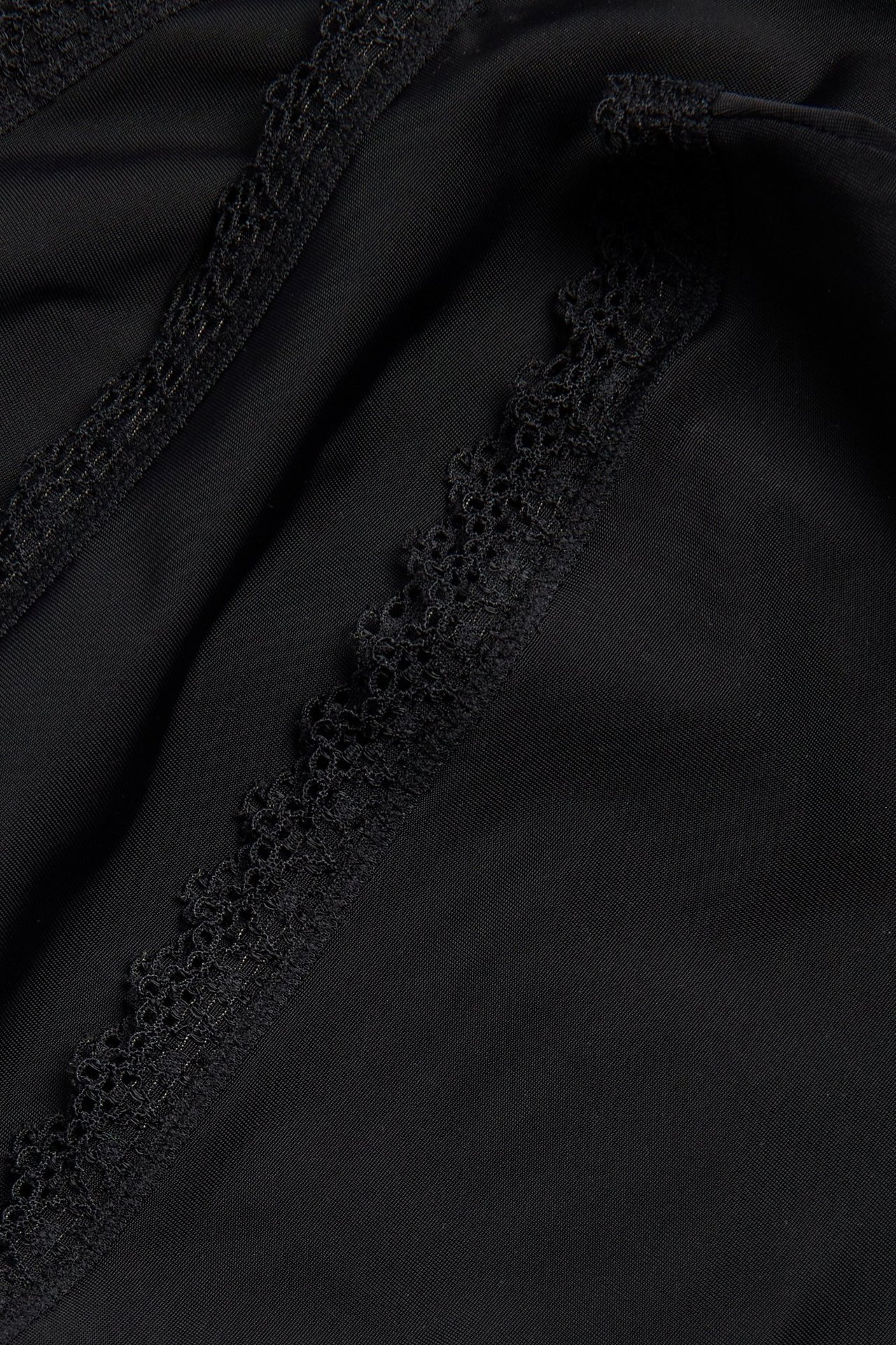 Närbild på svarta micro cheeky trosor med dekorativ svart spetskant.