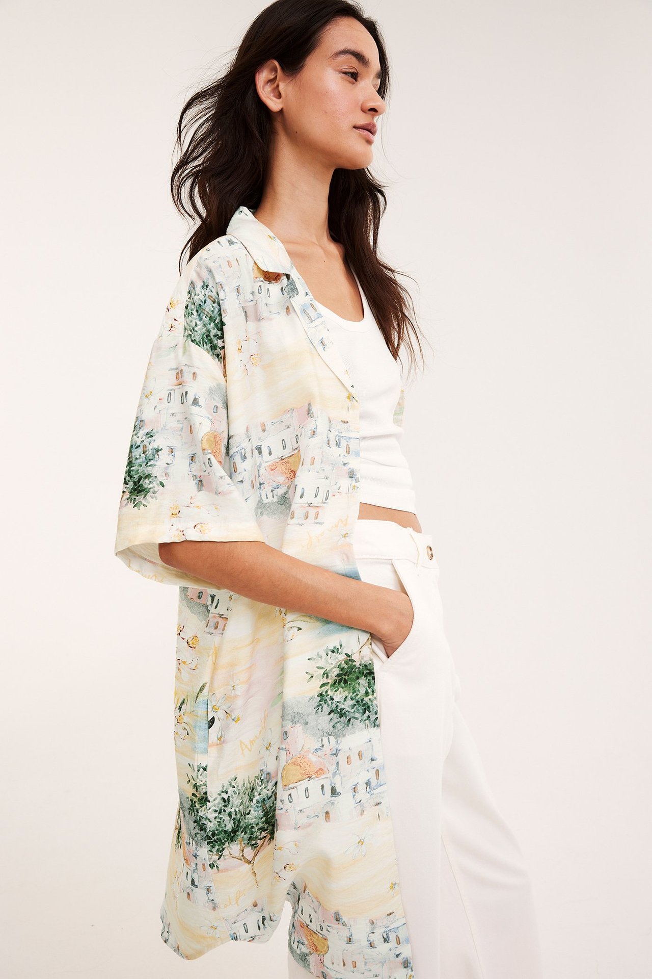 Framsida: Kvinna i off-white mönstrad kortärmad skjortklänning över vitt linne och byxor.