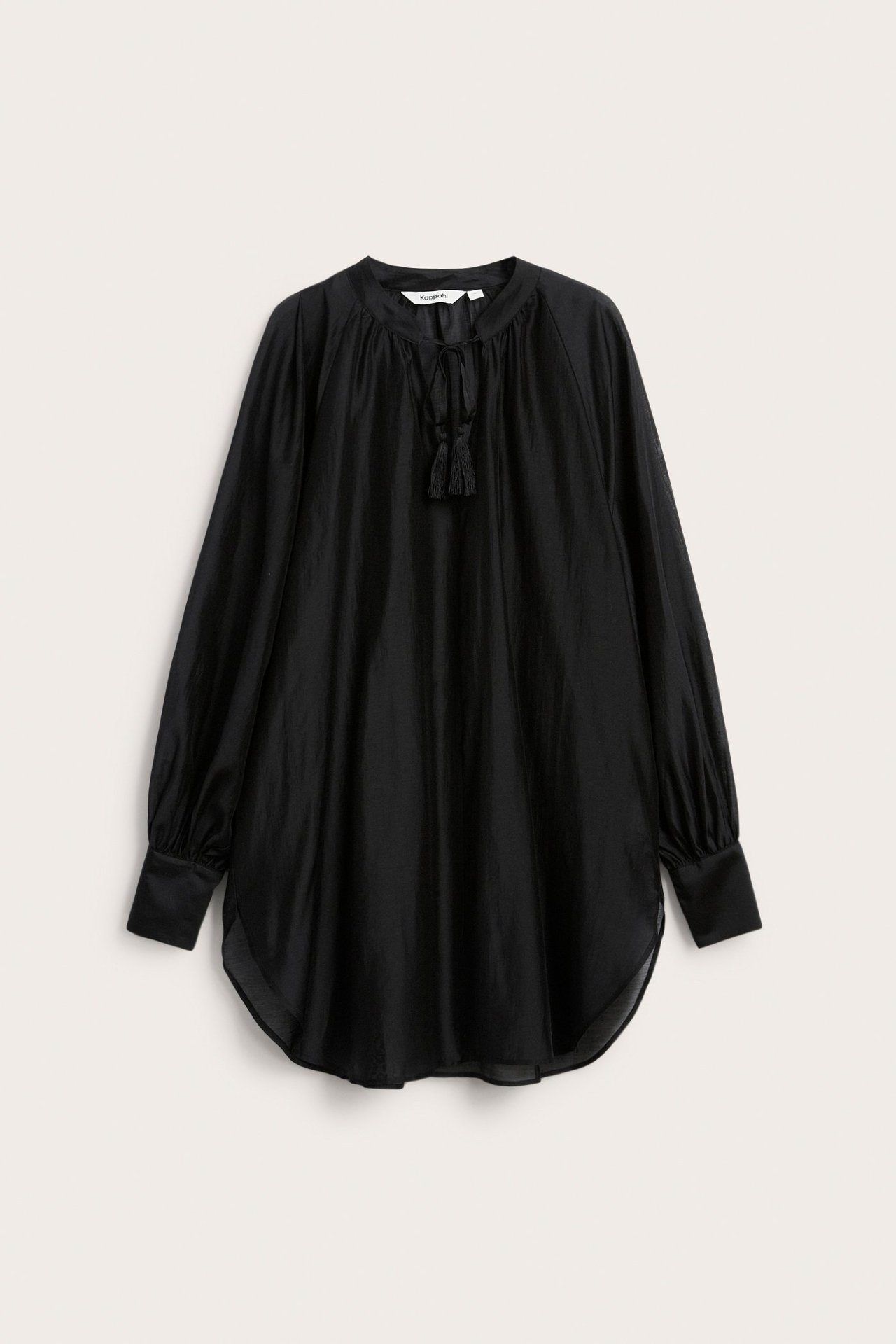 Forfra: Svart voluminøs bluse i lyocellblanding, med knytehals, dusker og lange ermer.