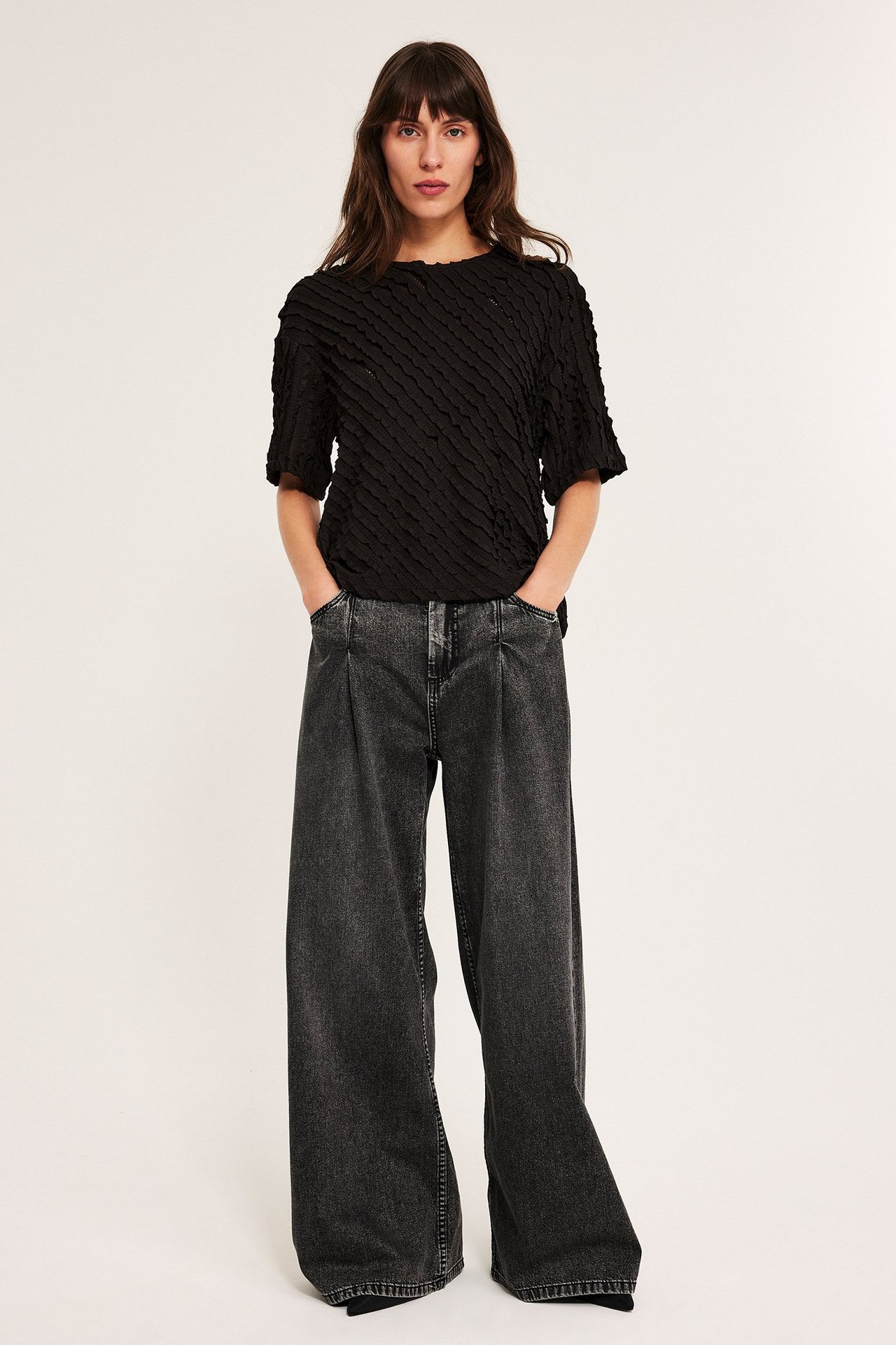 Svart strukturerad topp med korte ermer, stretch, ensfarget, på ung kvinne.