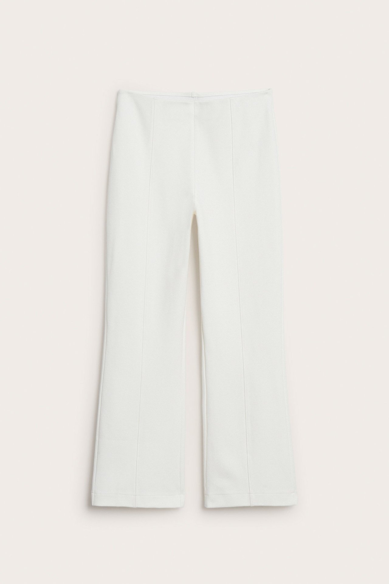 Edestä, luonnonvalkoiset pull-on-housut kickflare-istuvuudella ja etusaumoilla.