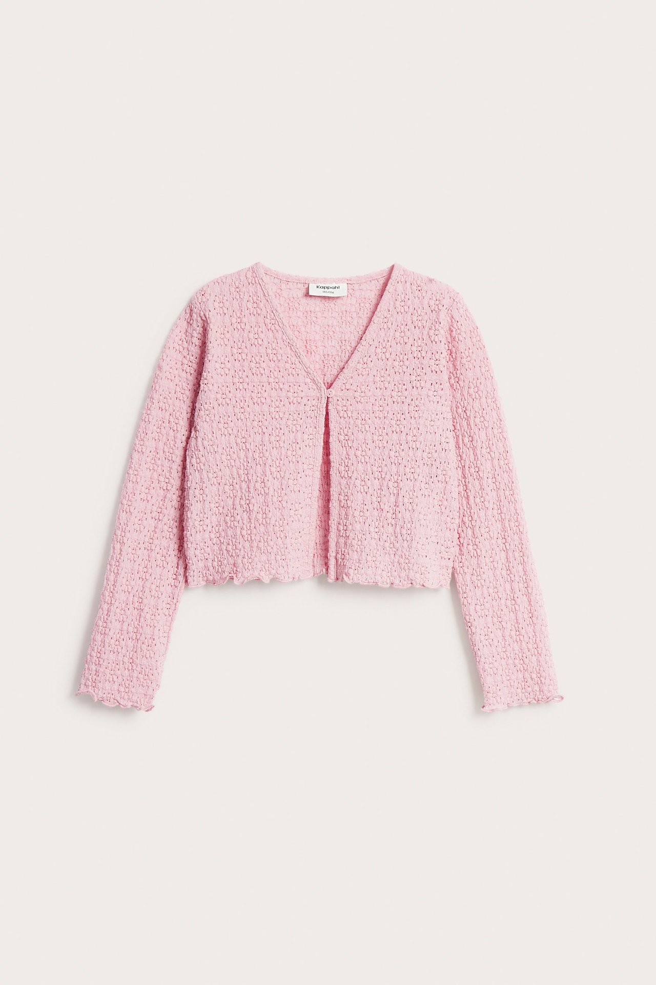 Edestä kuvattu vaaleanpunainen lasten pitsineuletakki, jossa yksi nappikiinnitys.