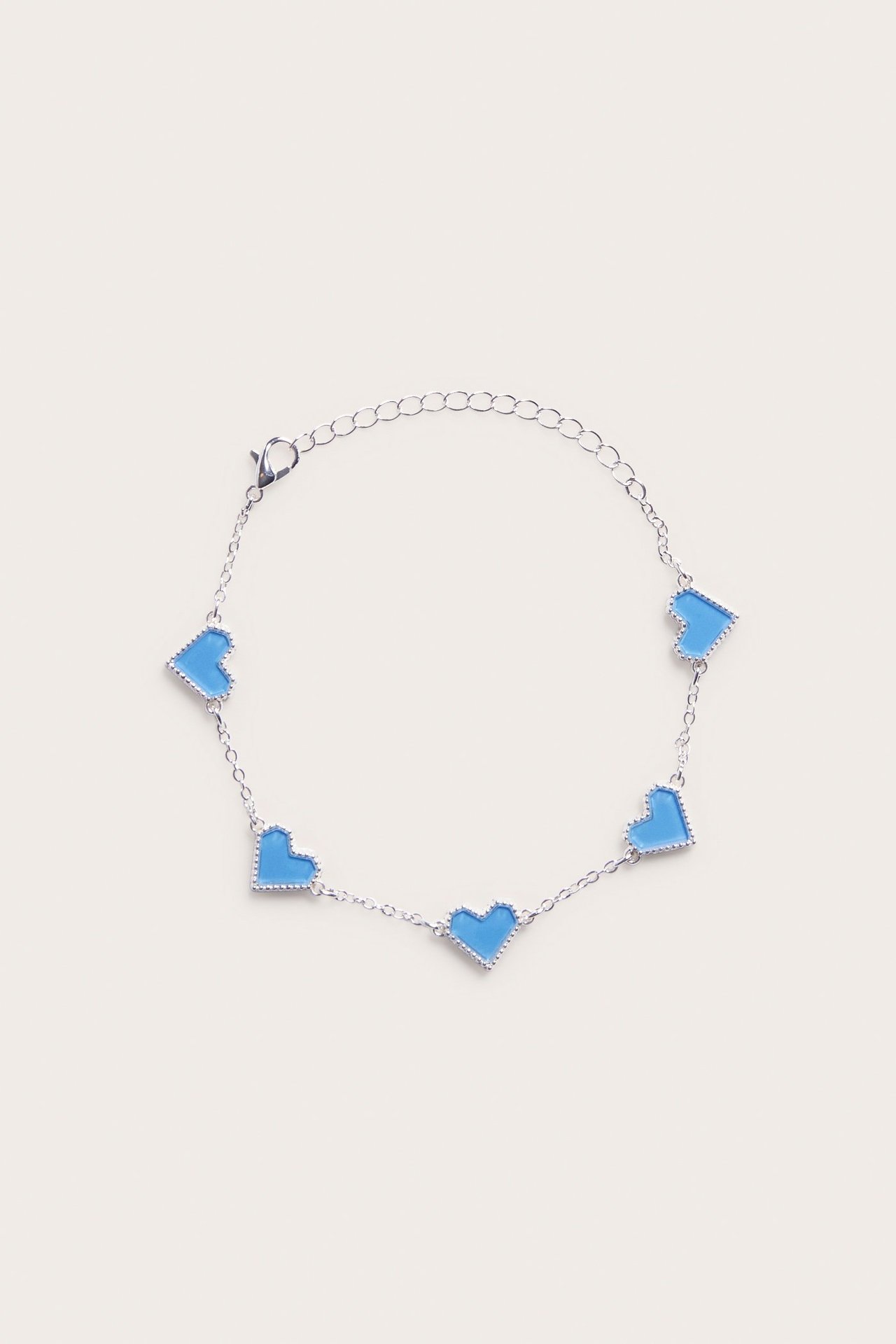 Widok z góry: metalowa bransoletka z pięcioma jasnoniebieskimi sercami i zapięciem karabinkowym.