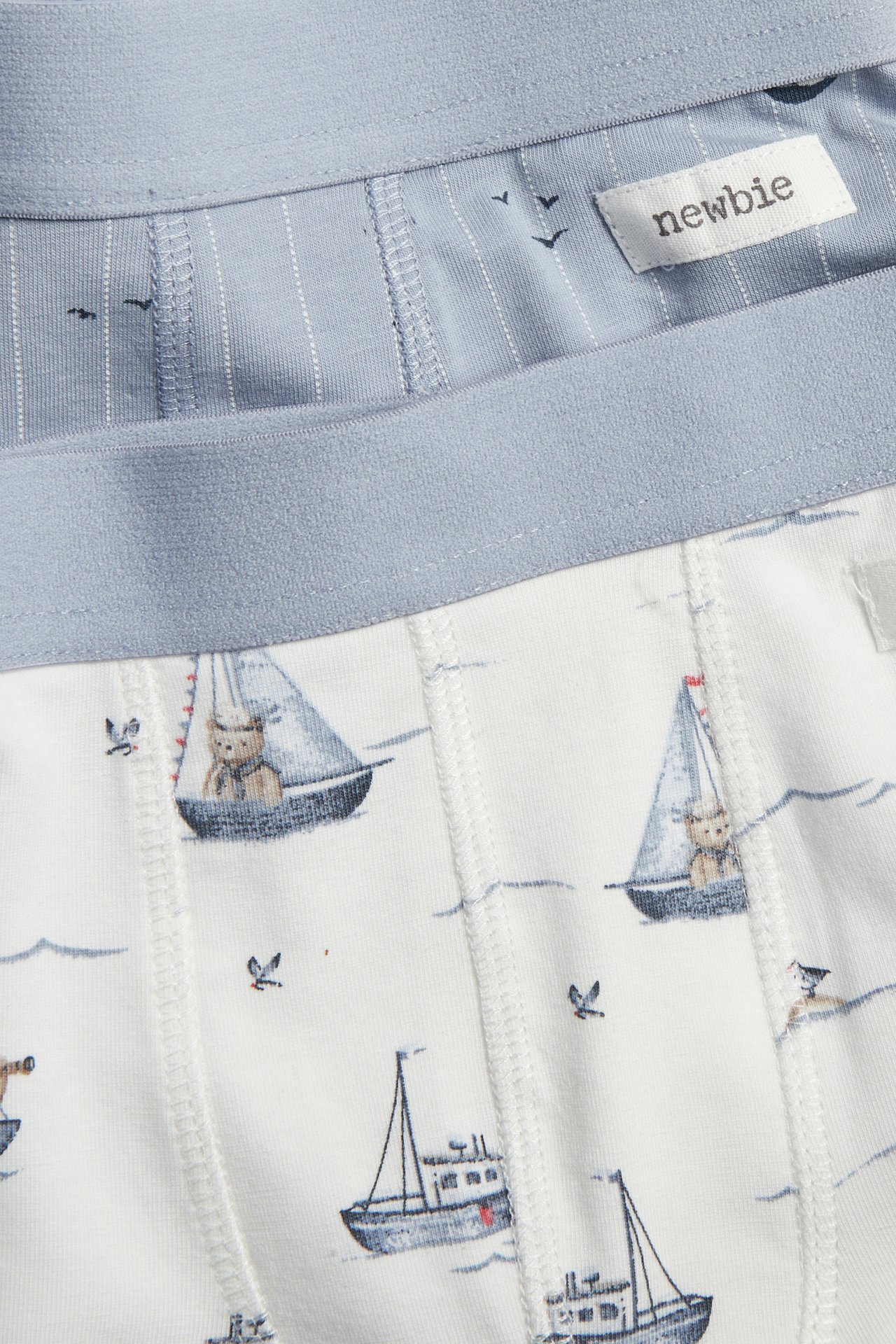 Lähikuva lasten kuvioidusta 2-pack bokserista: valkoinen purjeveneillä, sininen ohuilla raidoilla.