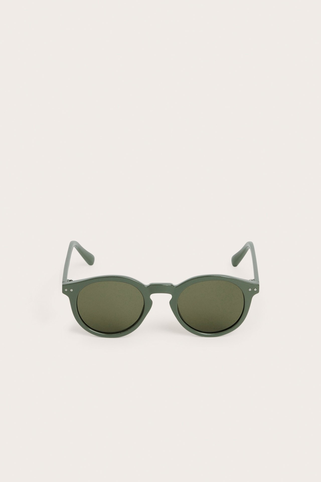 Edestäpäin kuvatut vihreät pyöreät muoviset aurinkolasit.