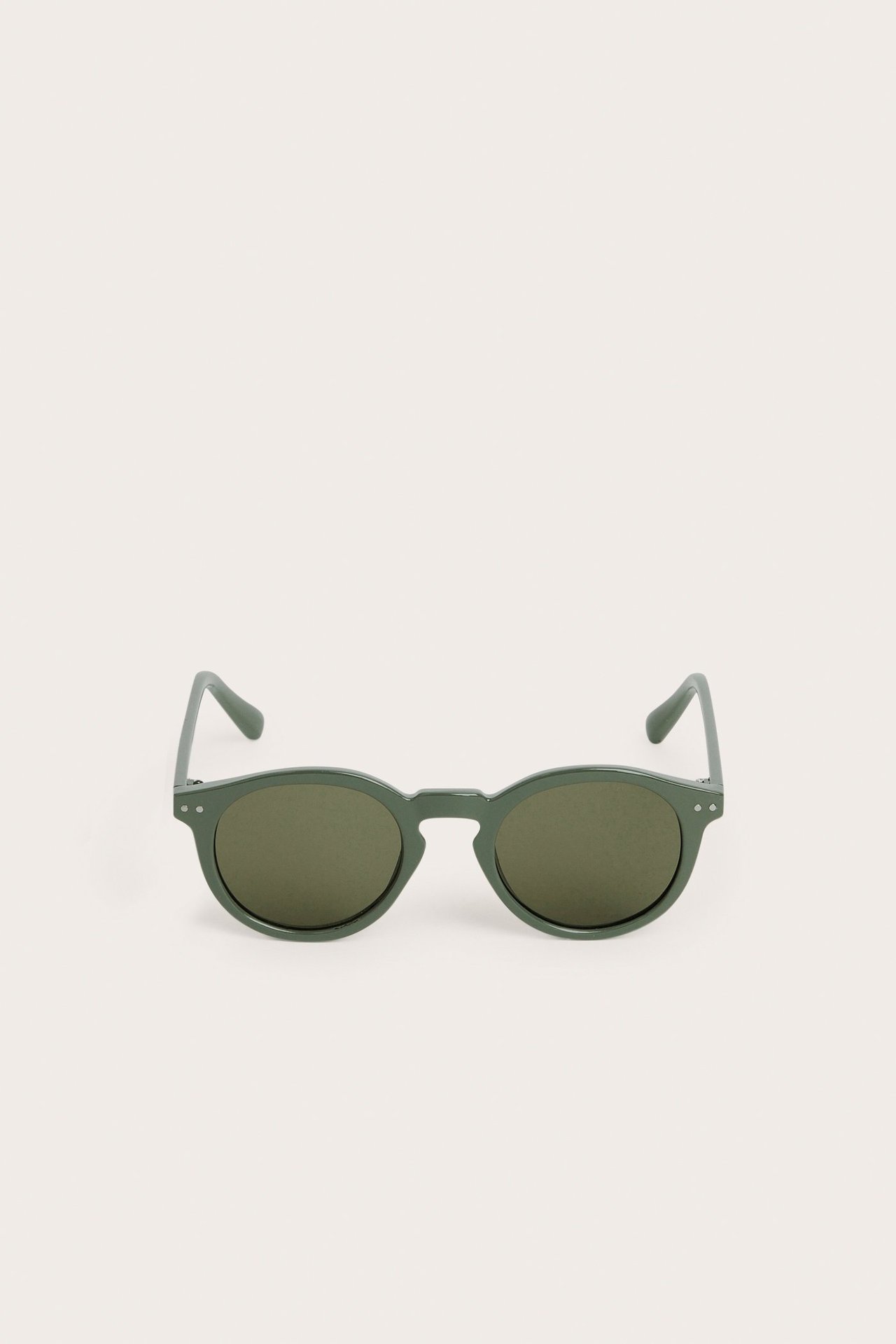 Edestäpäin kuvatut vihreät pyöreät muoviset aurinkolasit.