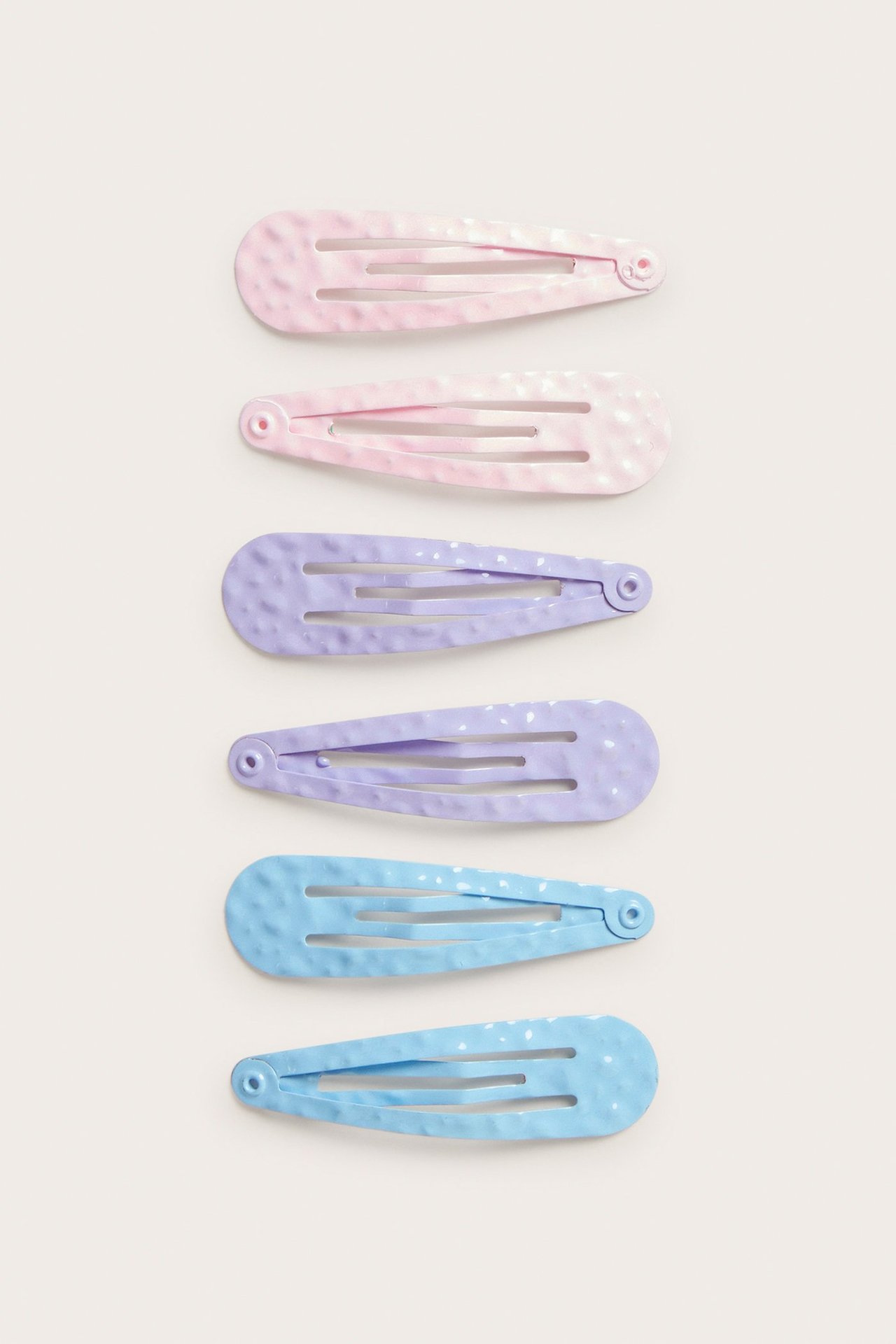 Widok z góry: Trzy pary metalowych spinek w różowym, fioletowym i jasnoniebieskim, z cętkowaną teksturą.