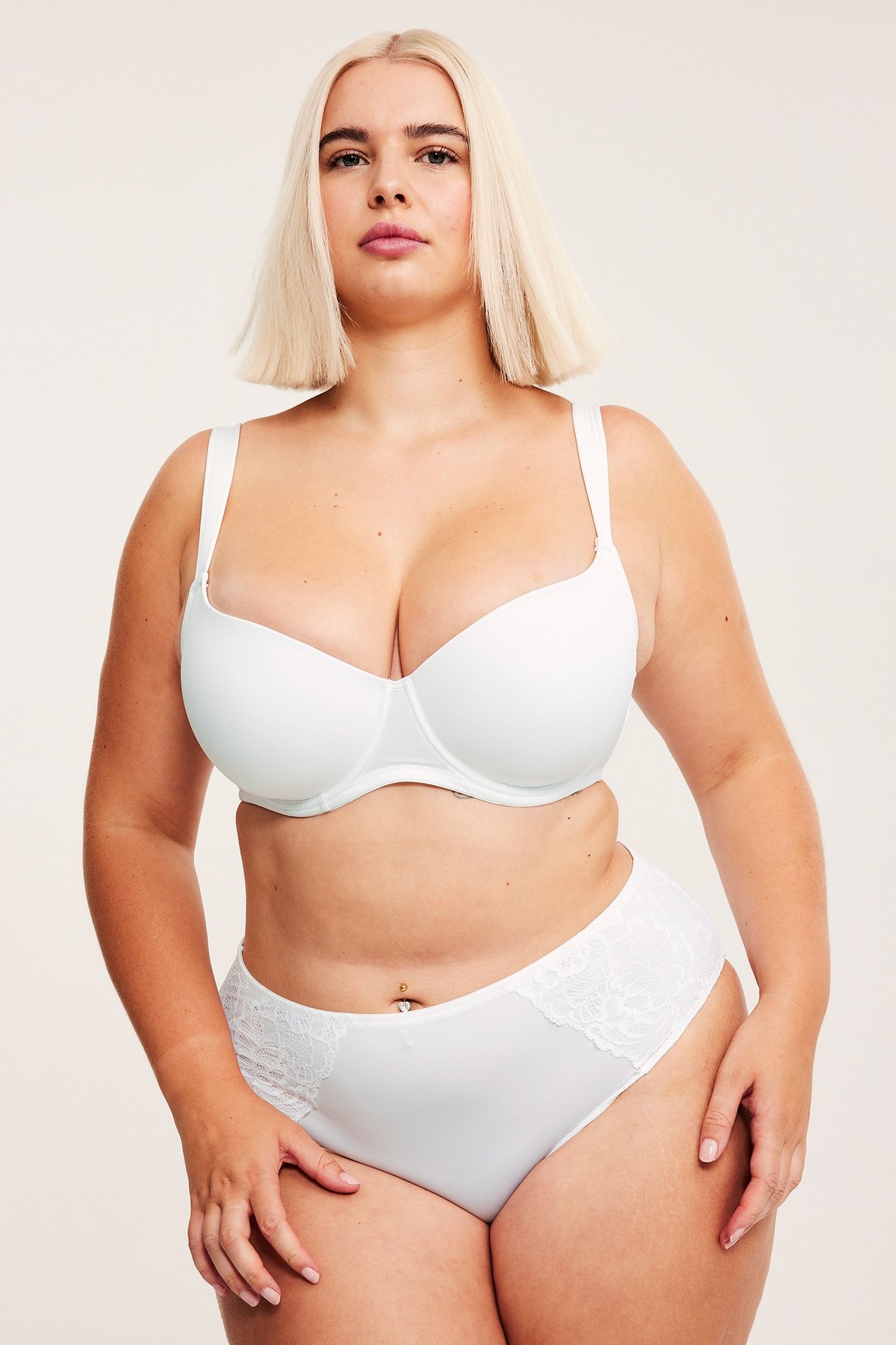 Forfra: kvinne i hvite microtruser med blondesider og matchende hvit BH.