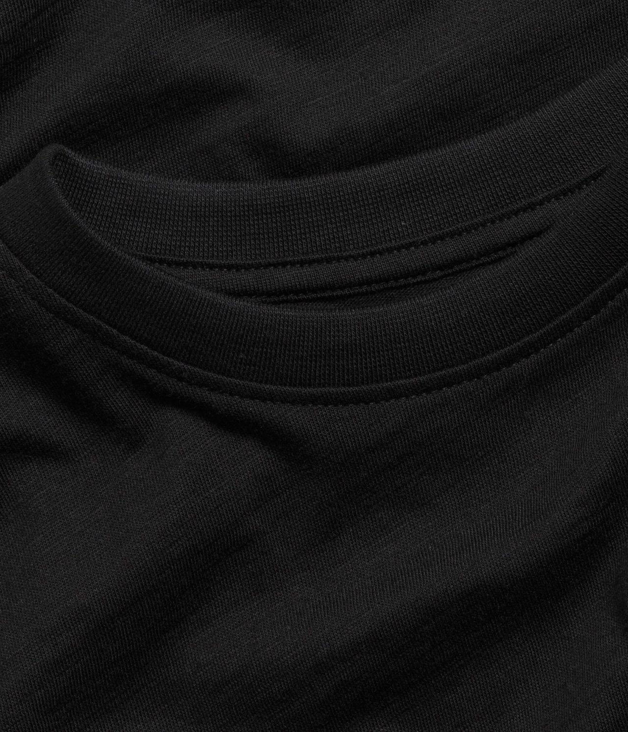 Zbliżenie czarnego bawełnianego t-shirtu, ukazujące prążkowany okrągły dekolt i teksturowany materiał.