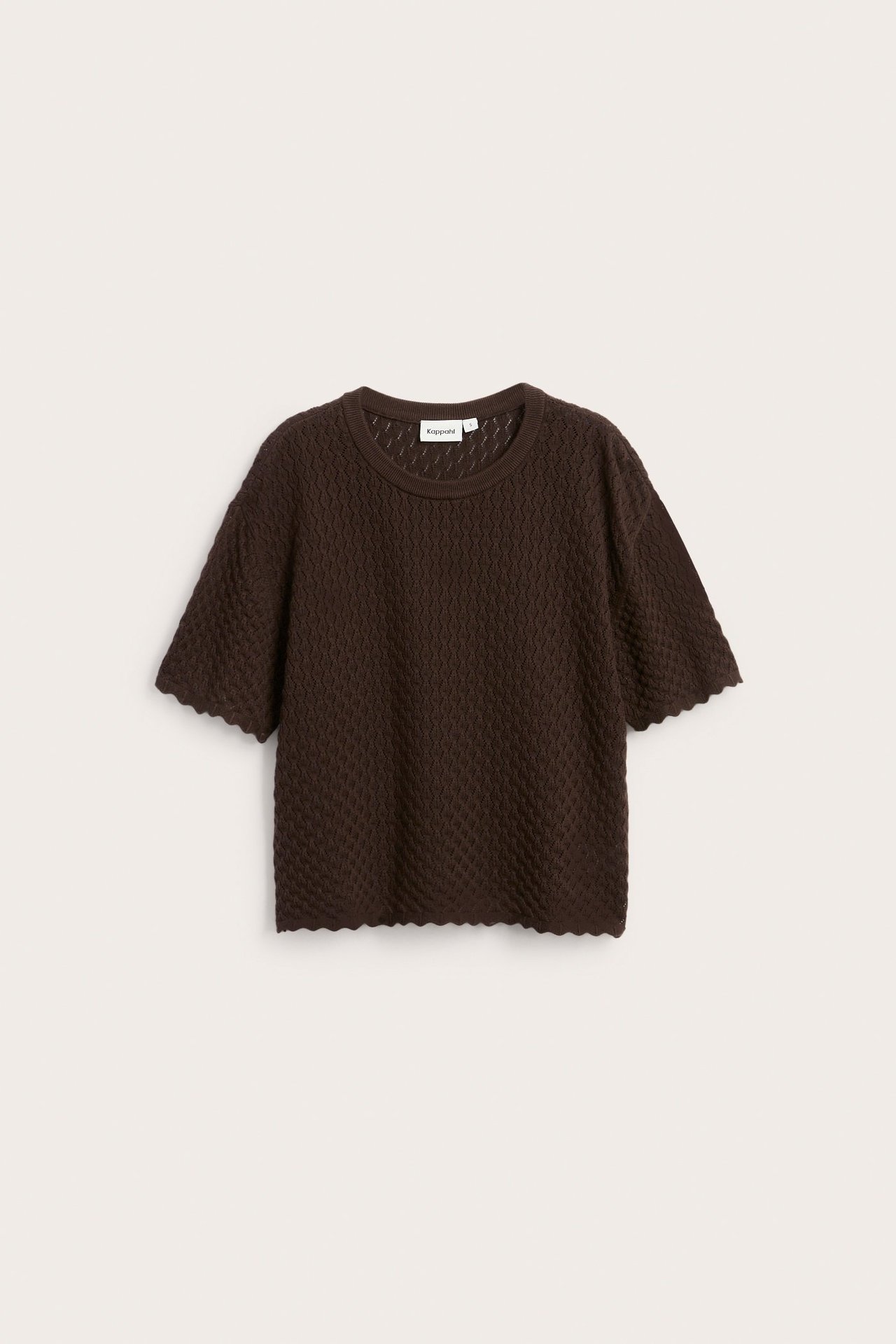 Widok z przodu ciemnobrązowego, wzorzystego, bawełnianego swetra z krótkim rękawem i falistymi brzegami.