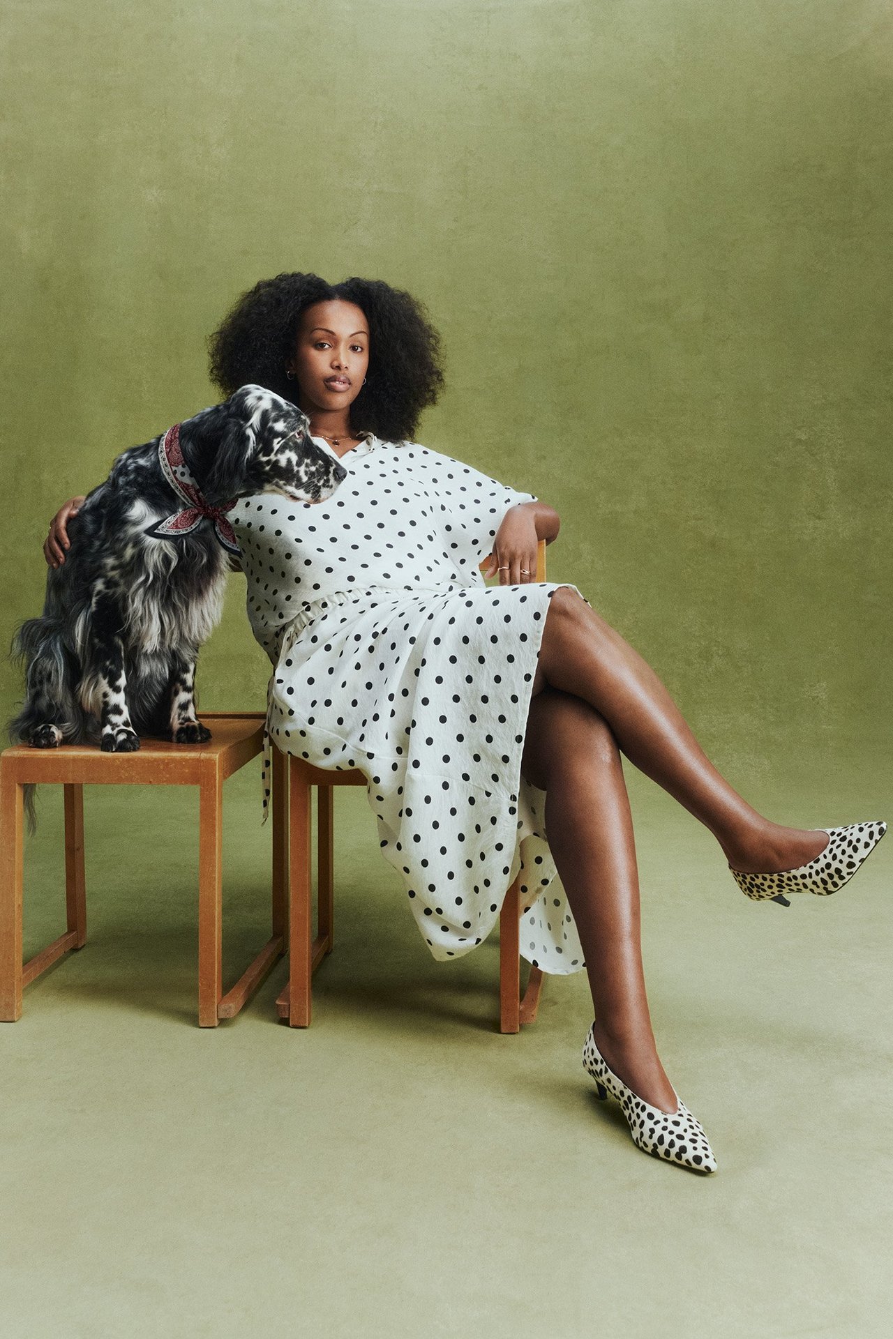 Widok z przodu: Kobieta w długiej, ecru spódnicy w kropki, pasującym topie i cętkowanych czółenkach.