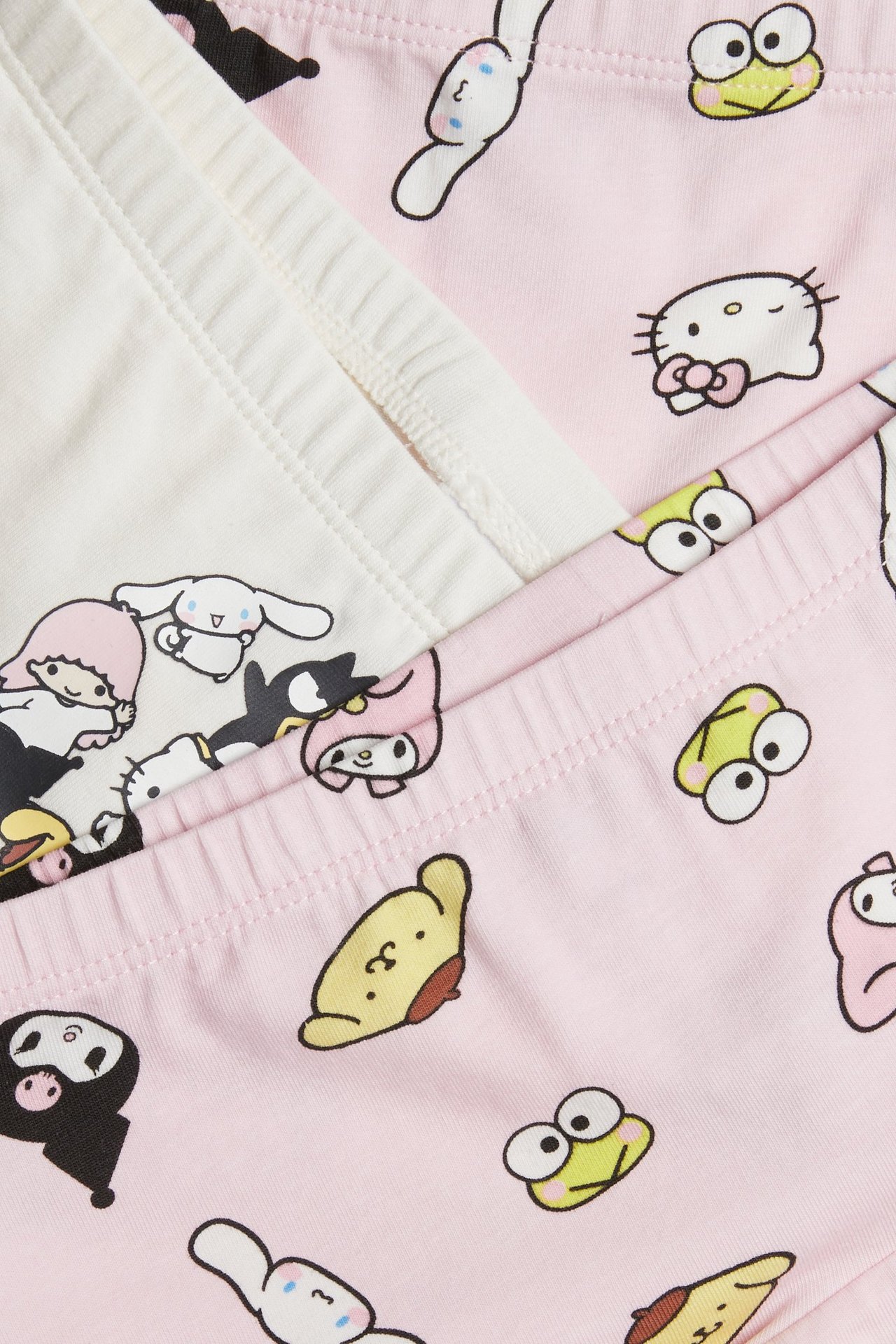 Zbliżenie na dziecięce bokserki w kolorze ecru i różowym z nadrukiem postaci Sanrio.