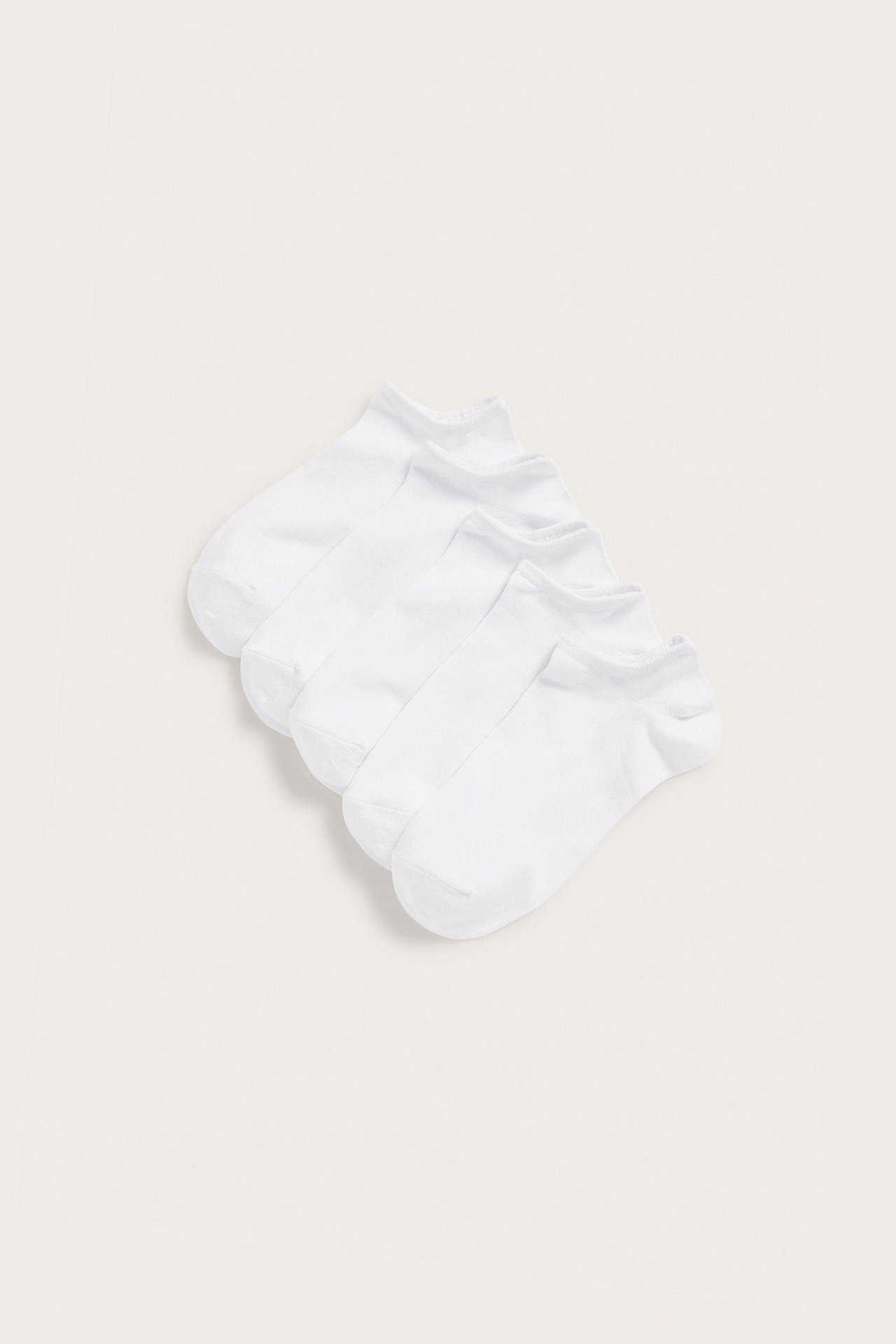 Flat lay av fem vita låga sneakersockar i bomullsblandning.