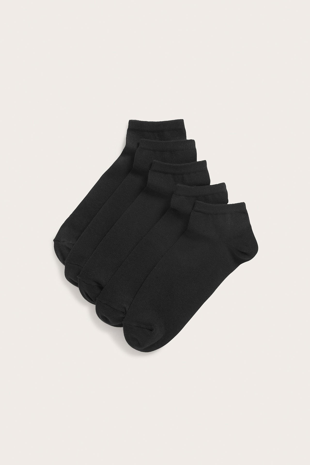 Ovenfra, fem par ensfargede svarte ankelstrømper for herre i bomullsblanding.