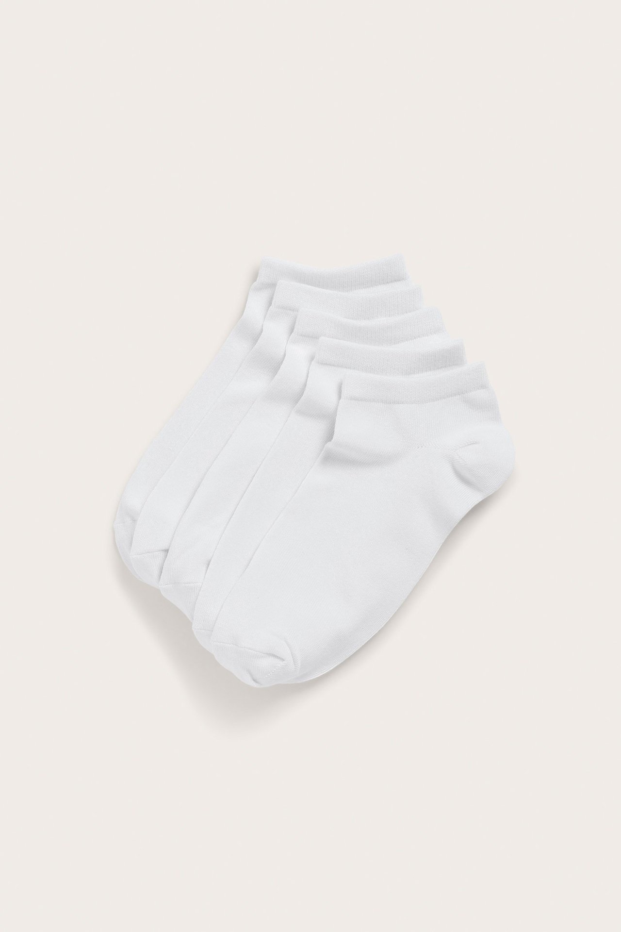 Widok z góry na pięć par białych, jednokolorowych męskich skarpetek.