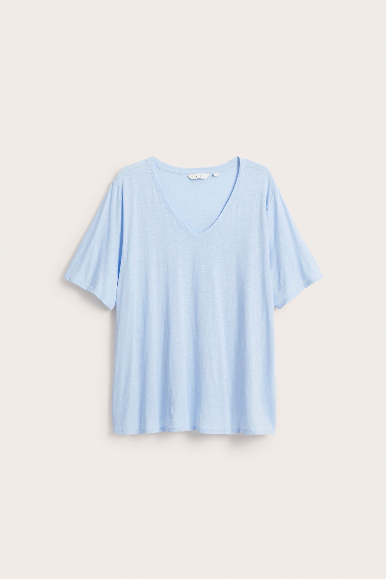 Edestäpäin vaaleansininen, yksivärinen, lyhythihainen, V-aukkoinen puuvillainen t-paita rennolla istuvuudella.