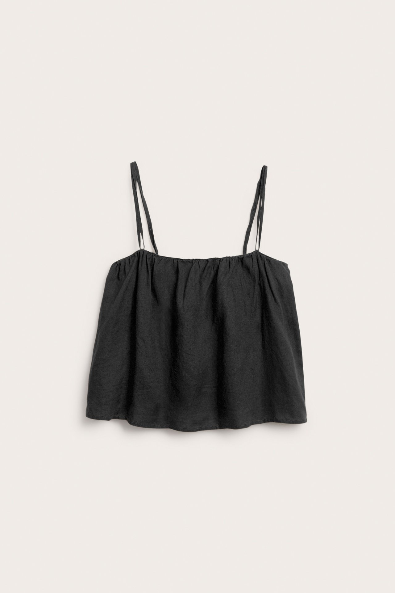 Frontvy av ett svart linne i linne med smala axelband och rynkad halslinning.