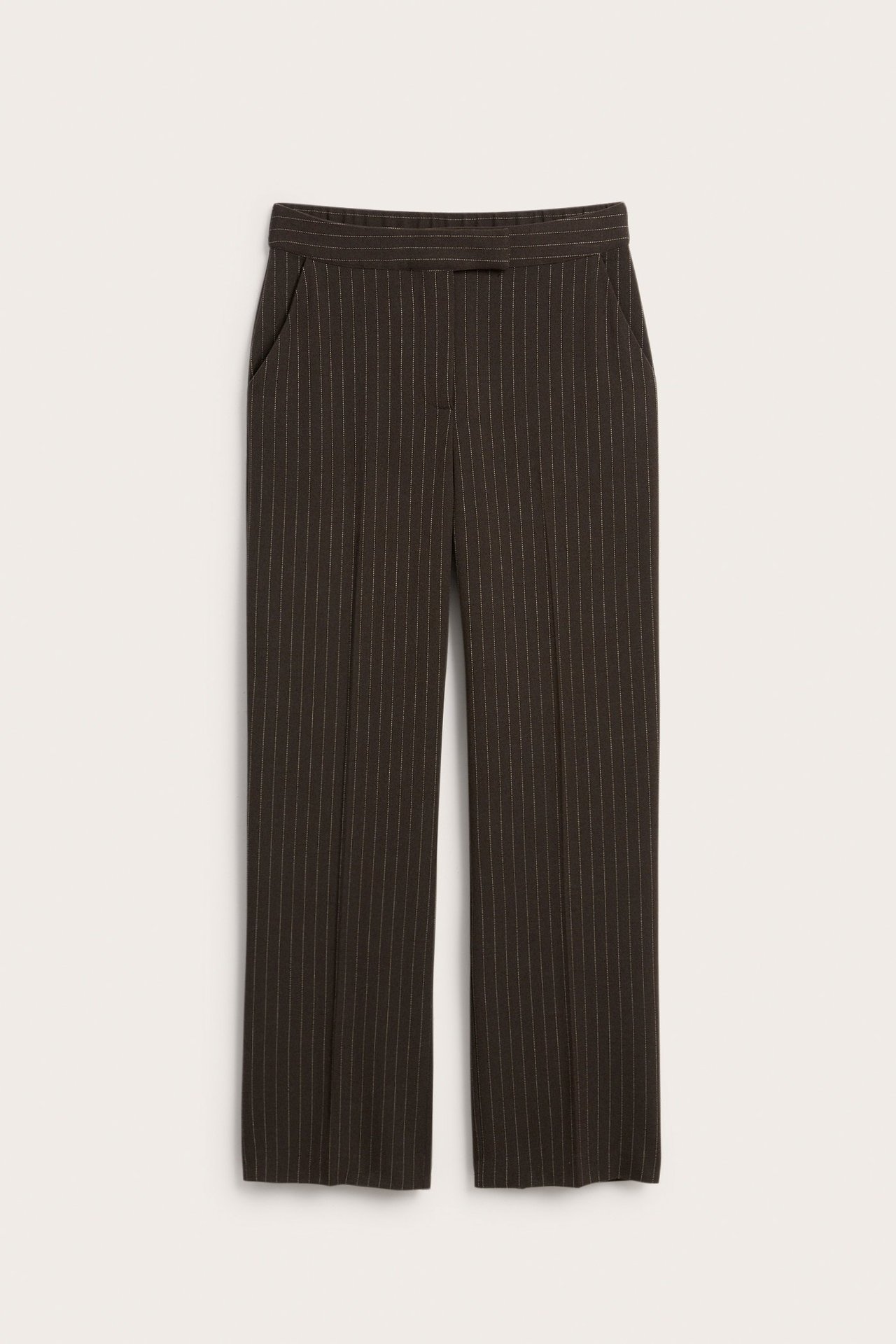 Widok z przodu ciemnobrązowych, prążkowanych spodni garniturowych o luźnym kroju z zapięciem i kieszeniami.