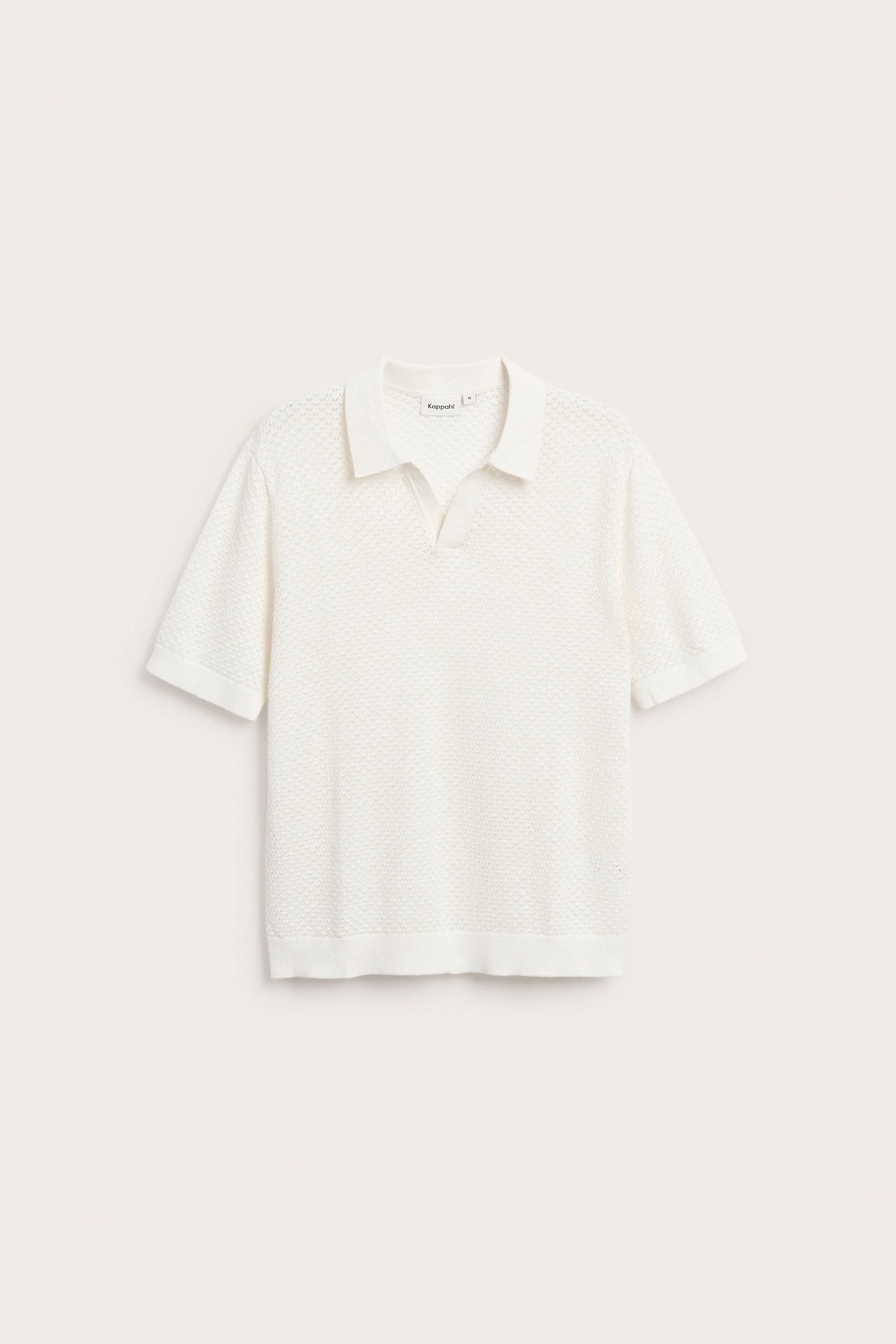 Framifrån, en offwhite stickad kortärmad pikétröja för män med litet hålmönster.