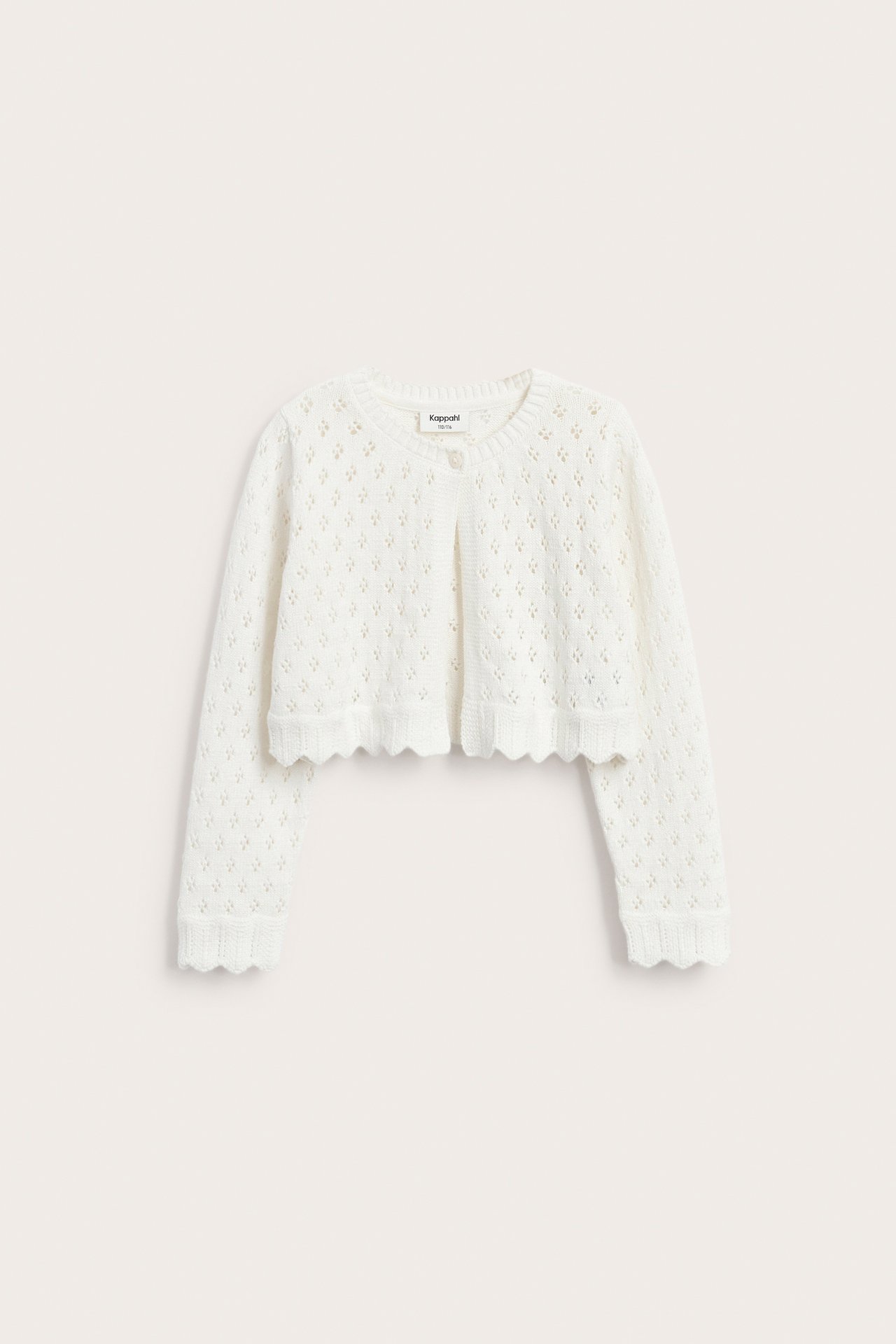 Edestä: Luonnonvalkoinen lasten neulottu puuvillatakki, jossa reikäkuvio, yksi nappi ja aaltoilevat reunat.