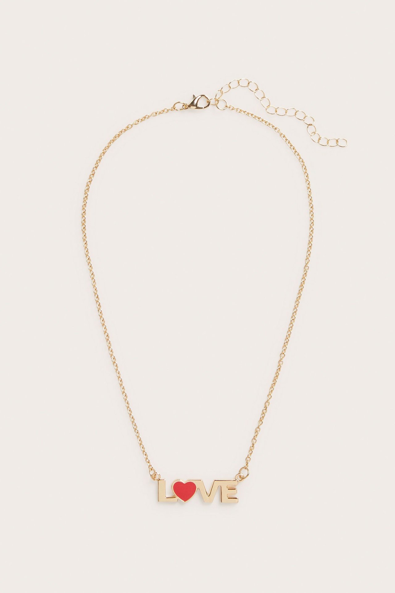 Edestäpäin, kullanvärinen metallikaulakoru, jossa "LOVE"-riipus ja punainen sydän "O":n tilalla, papukaijalukolla.