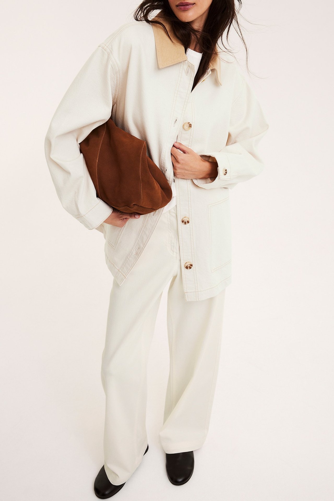 Widok z przodu: kobieta w beżowej kurtce twillowej z kołnierzem sztruksowym, pasujących spodniach, czarnych butach, z brązową torebką.