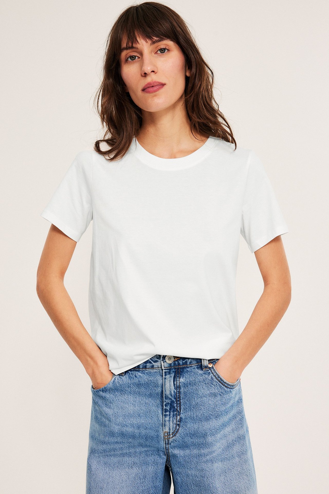 Vit T-shirt med rak passform i bomull, modell visar frontvy, casual stil.