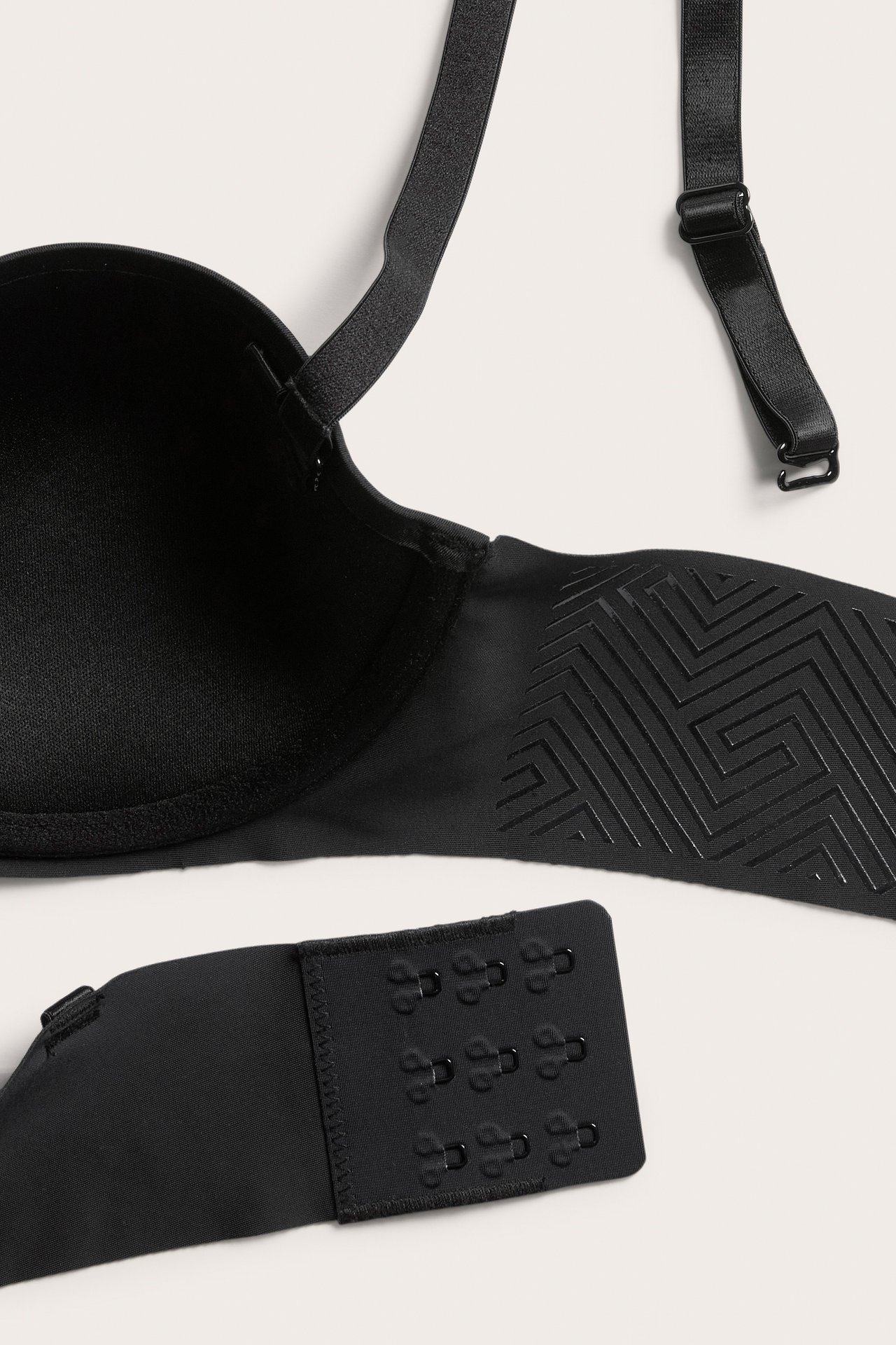 Zbliżenie czarnego biustonosza balconette z mikrofibry, regulowane ramiączka, zapięcie na haftki.