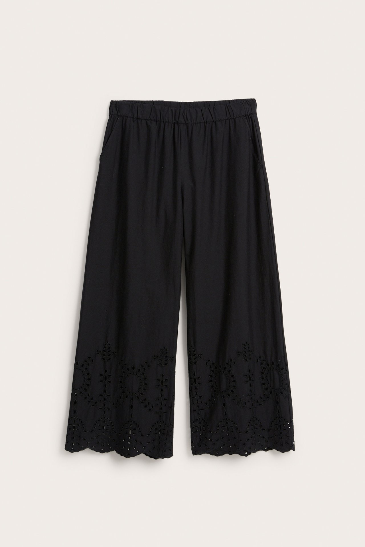 Forfra: svarte vide bukser i bomullspoplin med elastisk midje, sidelommer og broderi anglaise-kant.