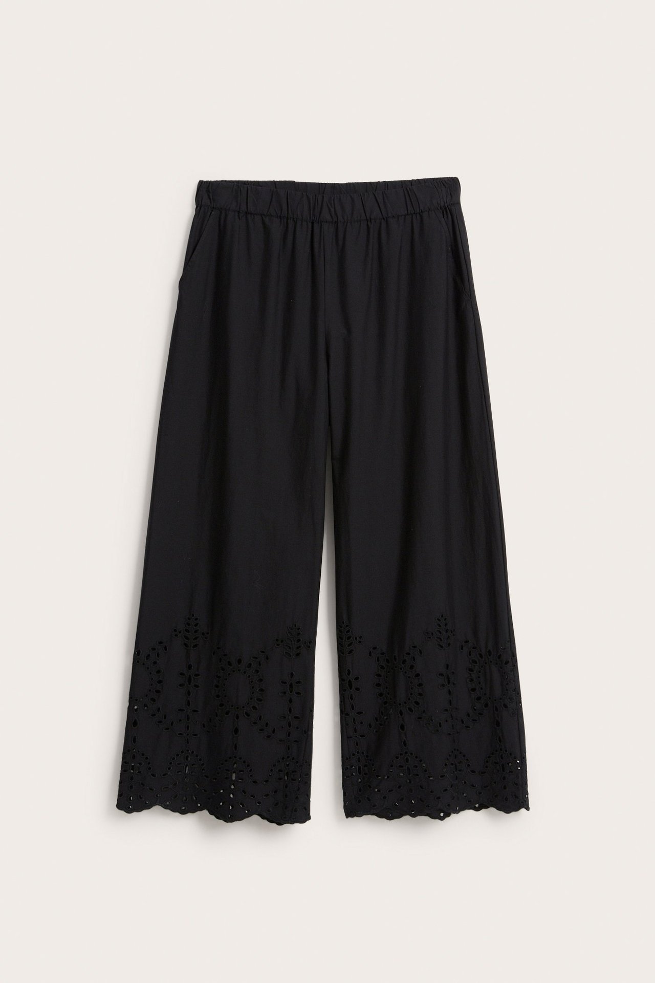 Edestä päin: mustat leveälahkeiset puuvillapopliinihousut, joissa kuminauhavyötärö, sivutaskut ja brodeerattu helma.