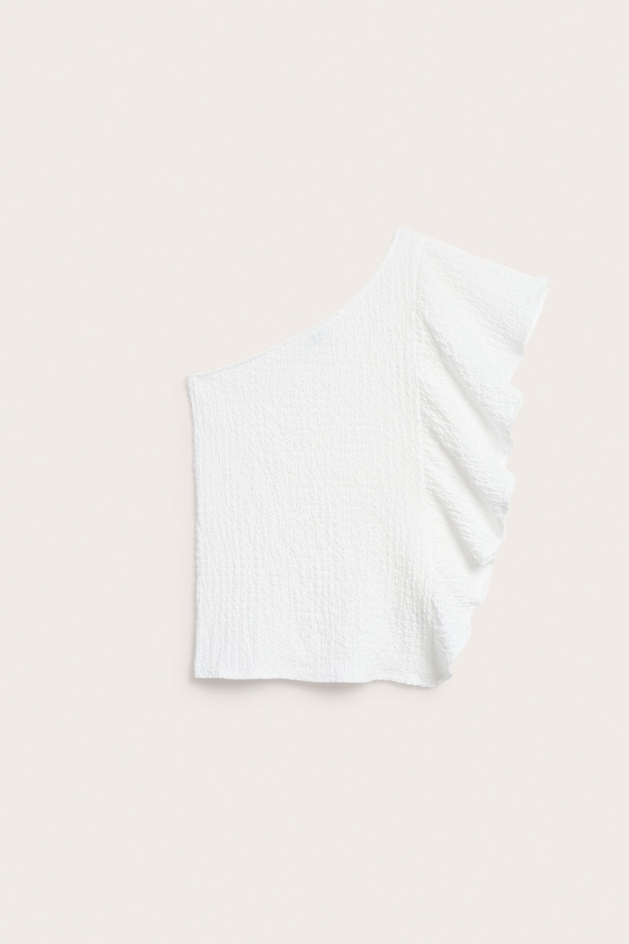 Widok z przodu na biały marszczony top na jedno ramię z falbanką.