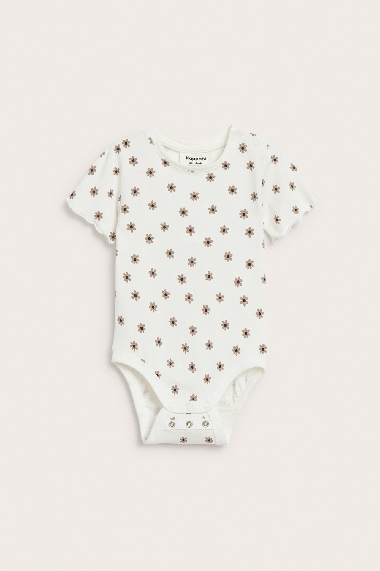 Luonnonvalkoinen vauvan lyhythihainen body pienellä kukkakuviolla, nepparit olalla ja haarassa.