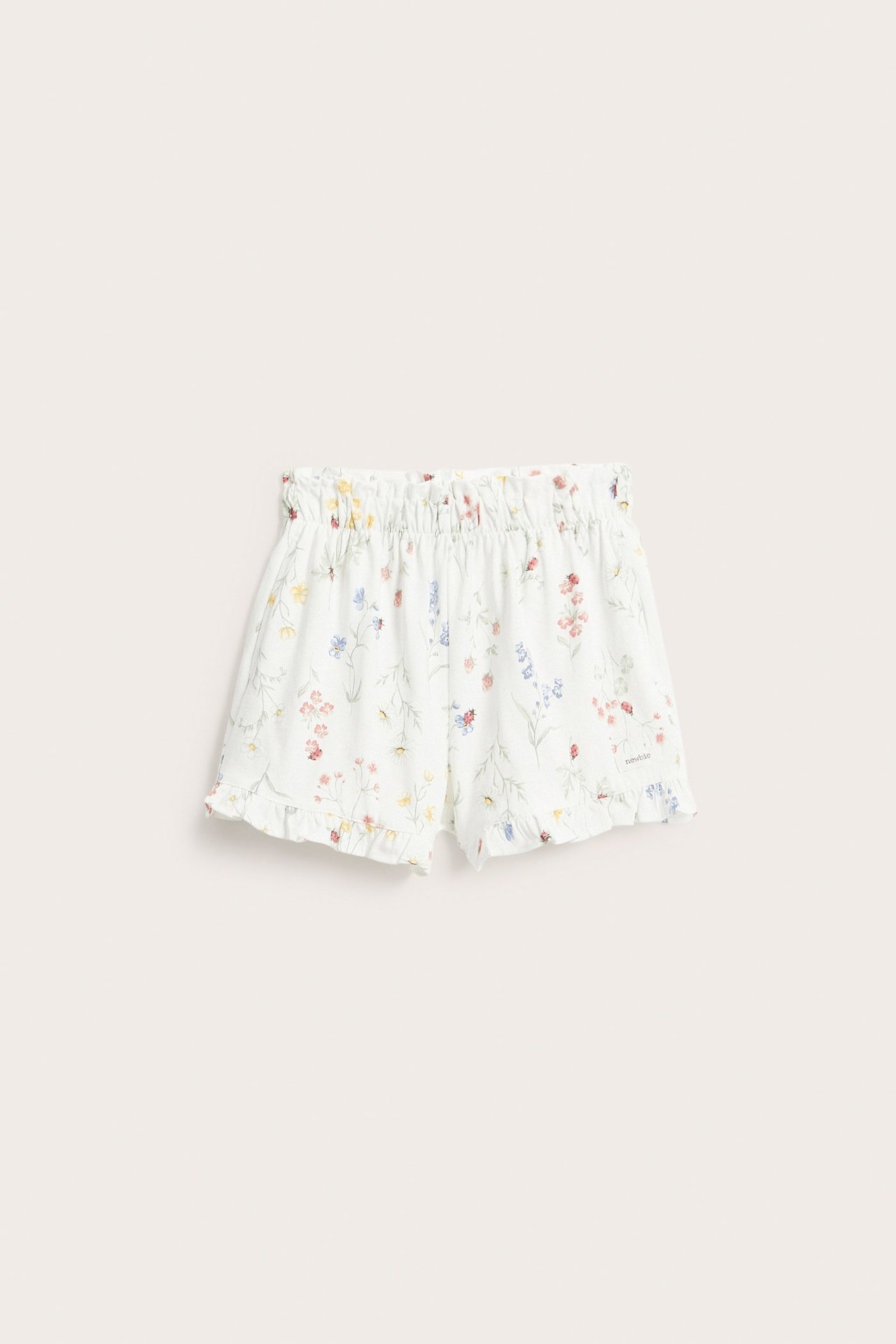 Forfra: Offwhite jersey shorts med blomster- og marihønemønster, resårmidje, volangkanter.
