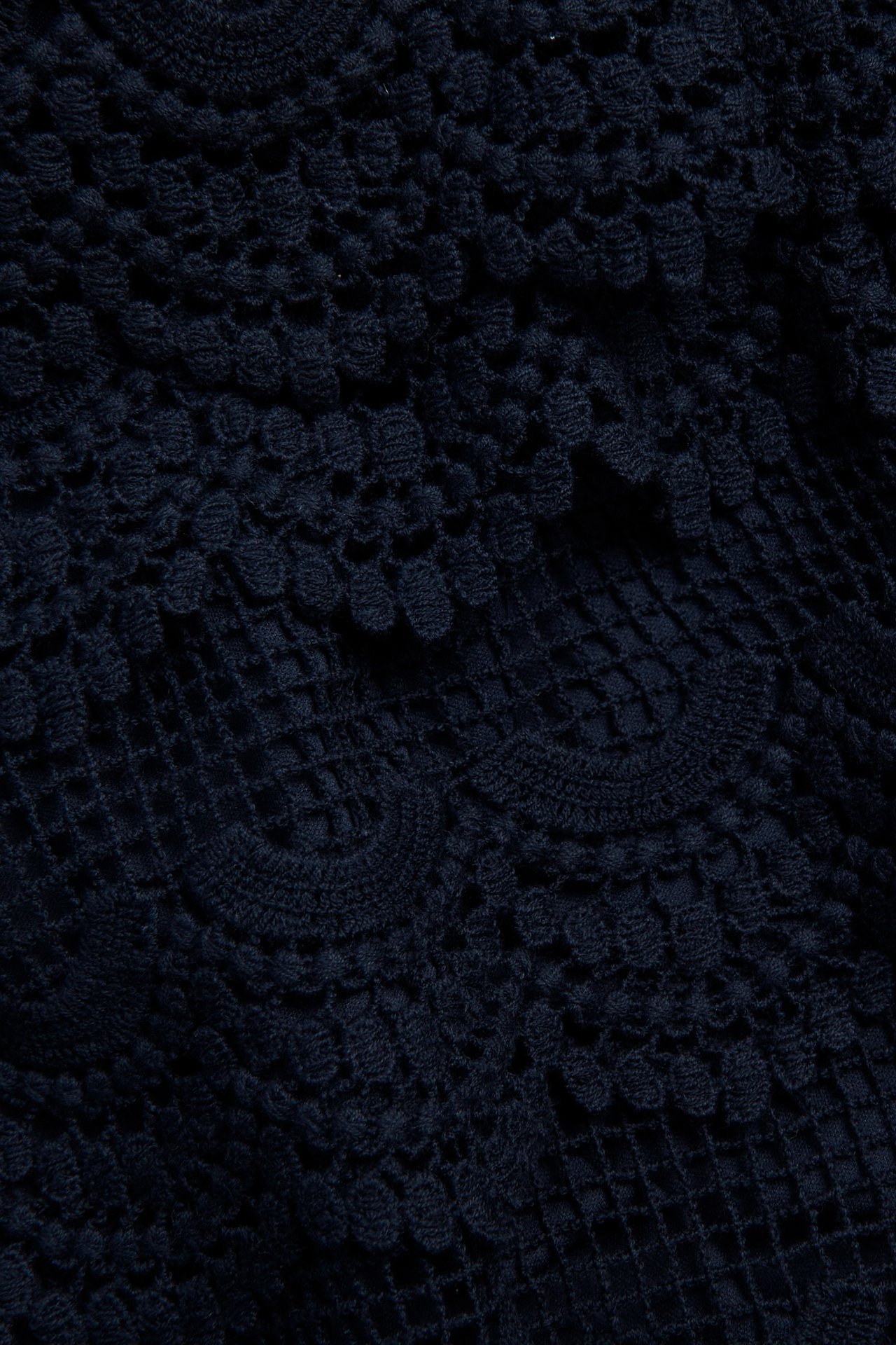 Zbliżenie na granatowe bawełniane koronkowe szorty z widoczną podszewką i misternymi wzorami kwiatowymi.