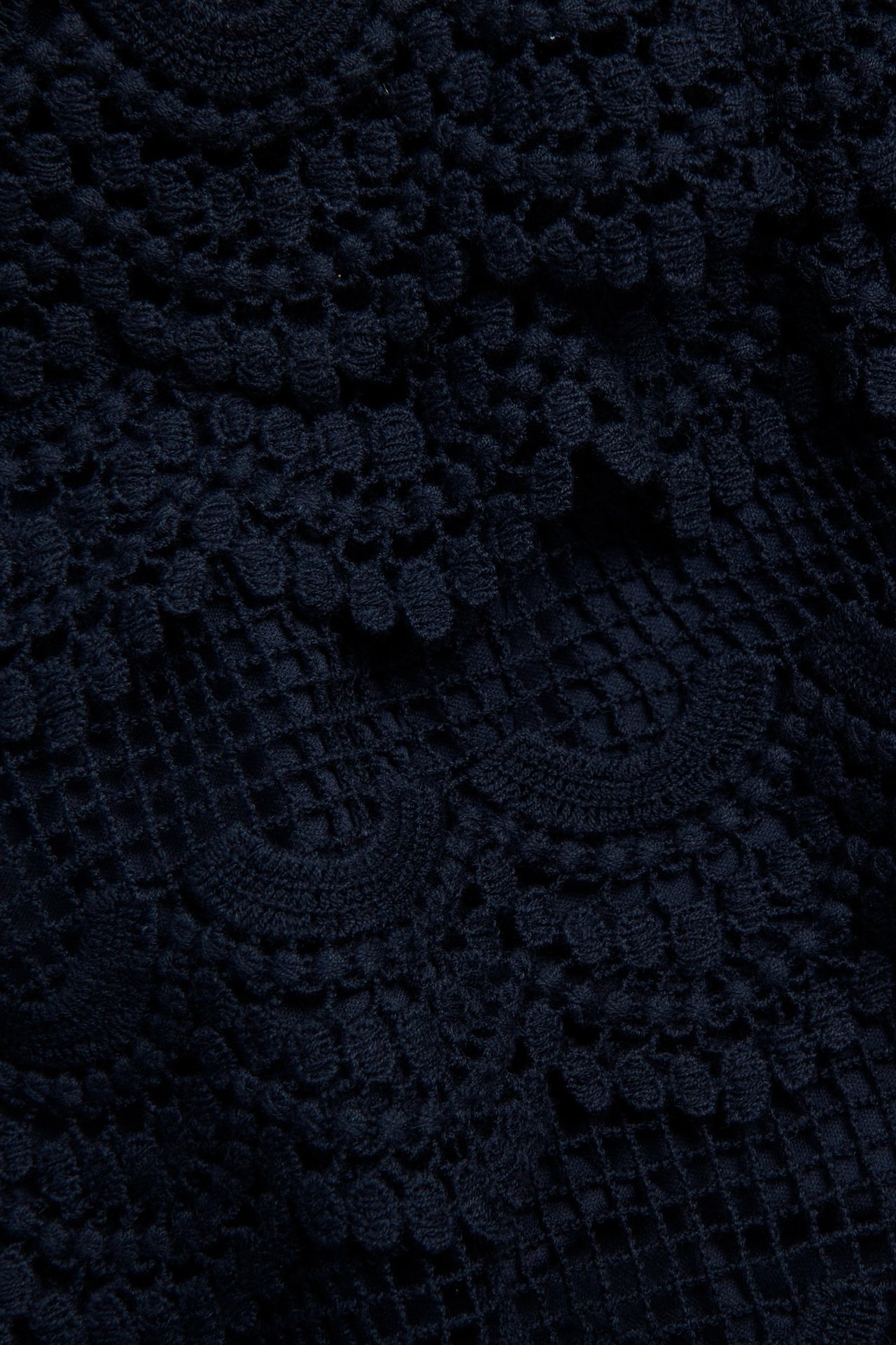 Zbliżenie na granatowe bawełniane koronkowe szorty z widoczną podszewką i misternymi wzorami kwiatowymi.