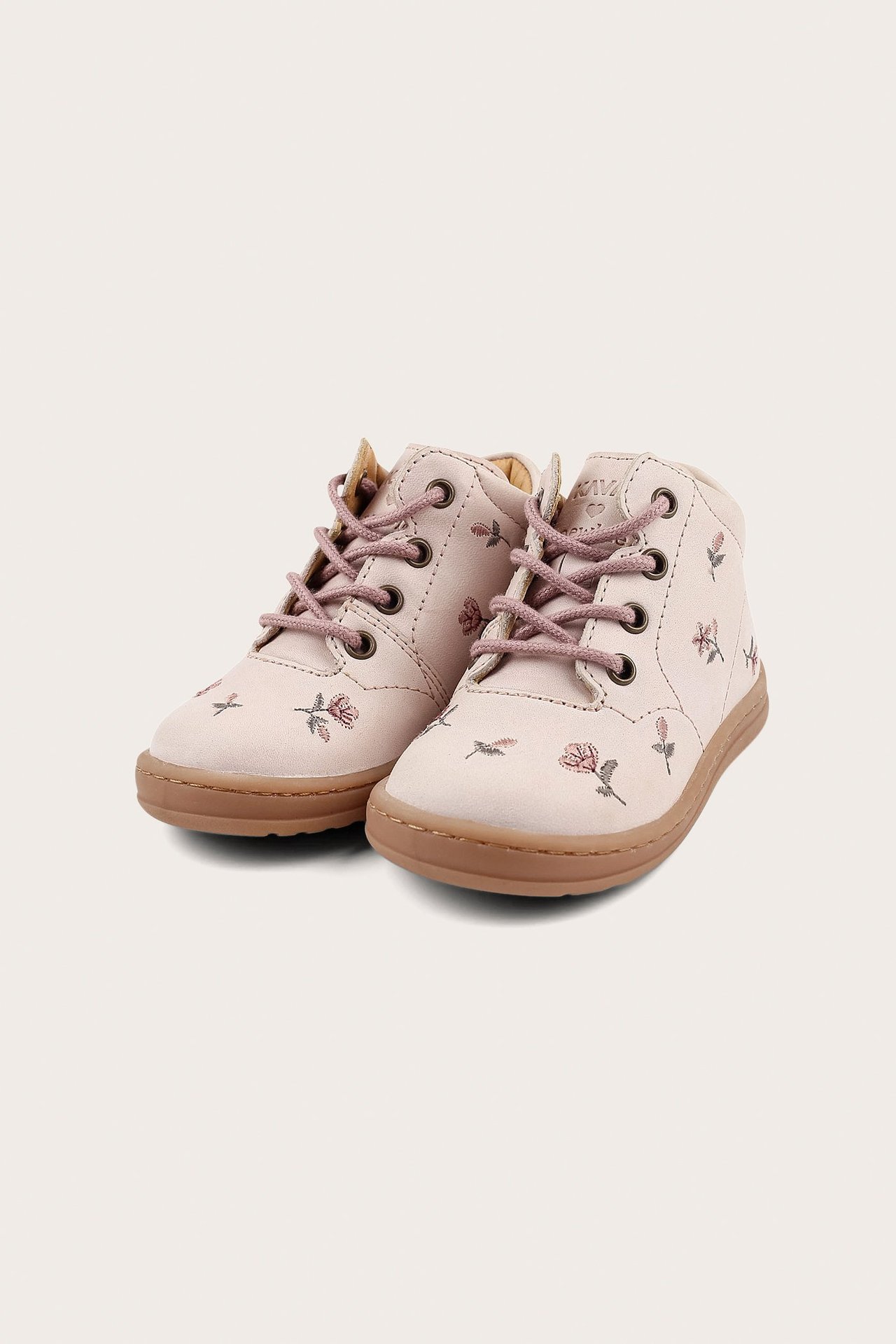 Widok z przodu: jasnoróżowe dziecięce buty w kwiaty, z różowymi sznurówkami i brązowymi podeszwami.