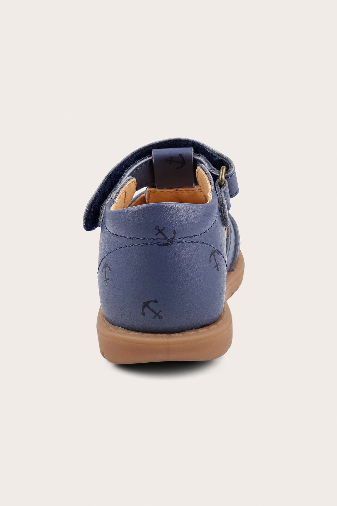 Takaa näkymä sinisestä lasten sandaalista ankkurikuvioinnilla, tarranauhakiristyksellä ja ruskealla pohjalla.