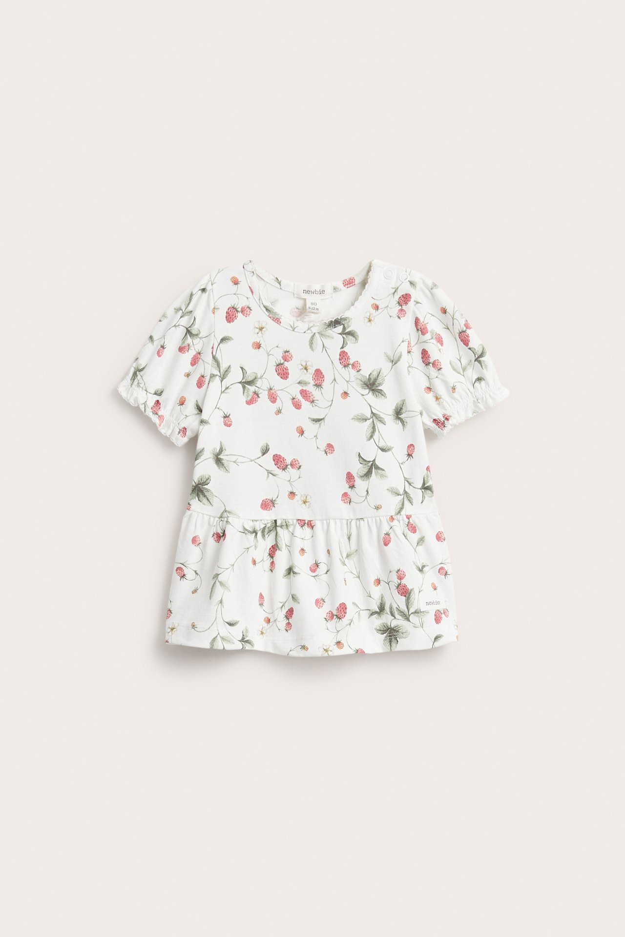 Frontvy: Off-white bomullsjerseytopp med peplum, puffärmar, tryckknappsaxel och jordgubbsmönster.