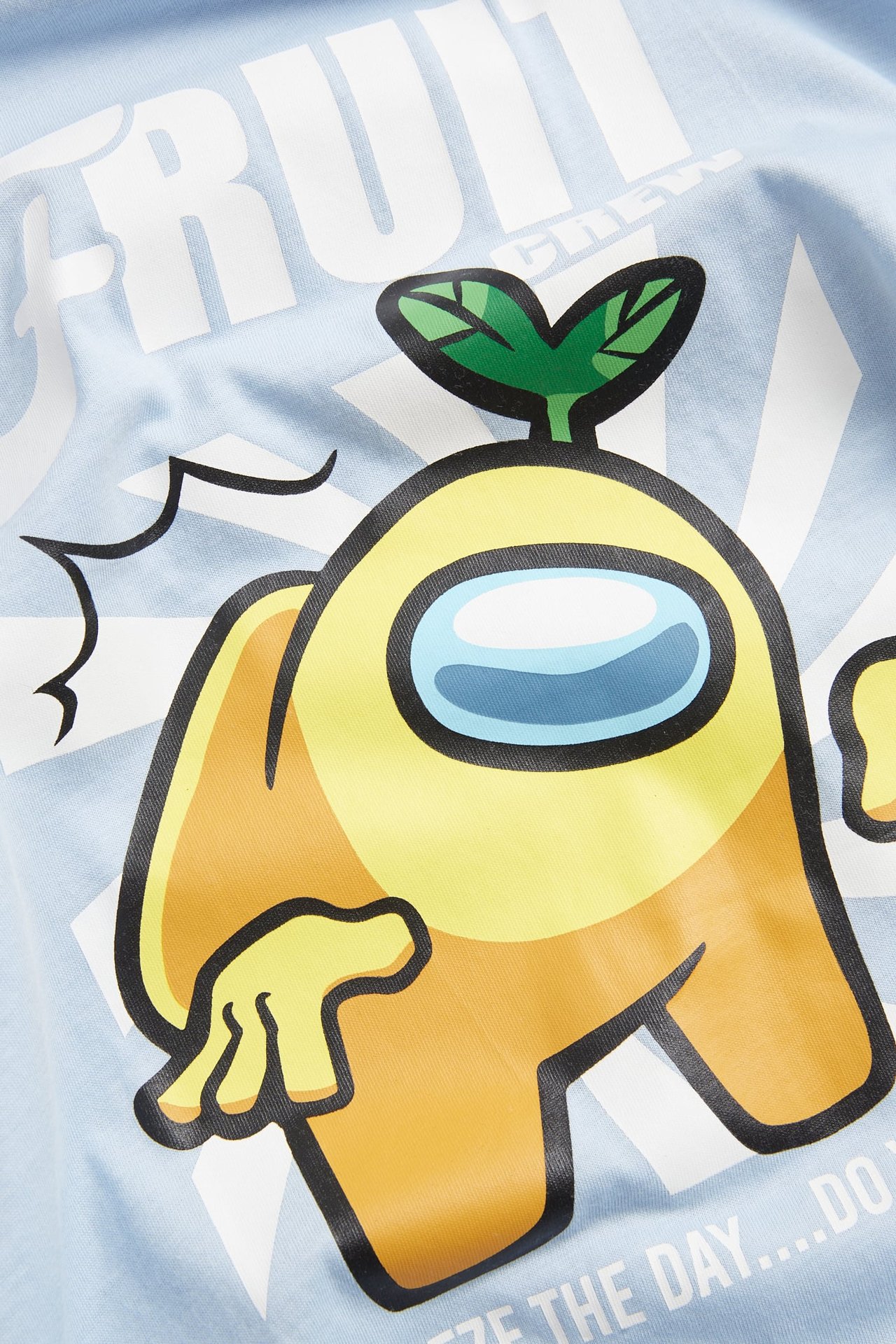 Zbliżenie na jasnoniebieski bawełniany t-shirt dziecięcy z żółtym nadrukiem postaci Among Us z przodu.