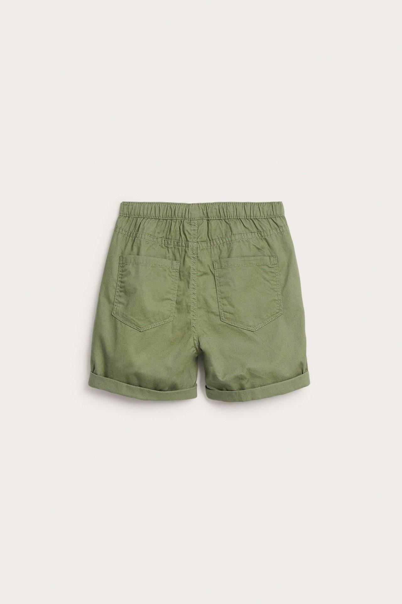 Widok z tyłu: ciemnozielone bawełniane szorty dziecięce z gumką w pasie, tylnymi kieszeniami i podwiniętymi nogawkami.