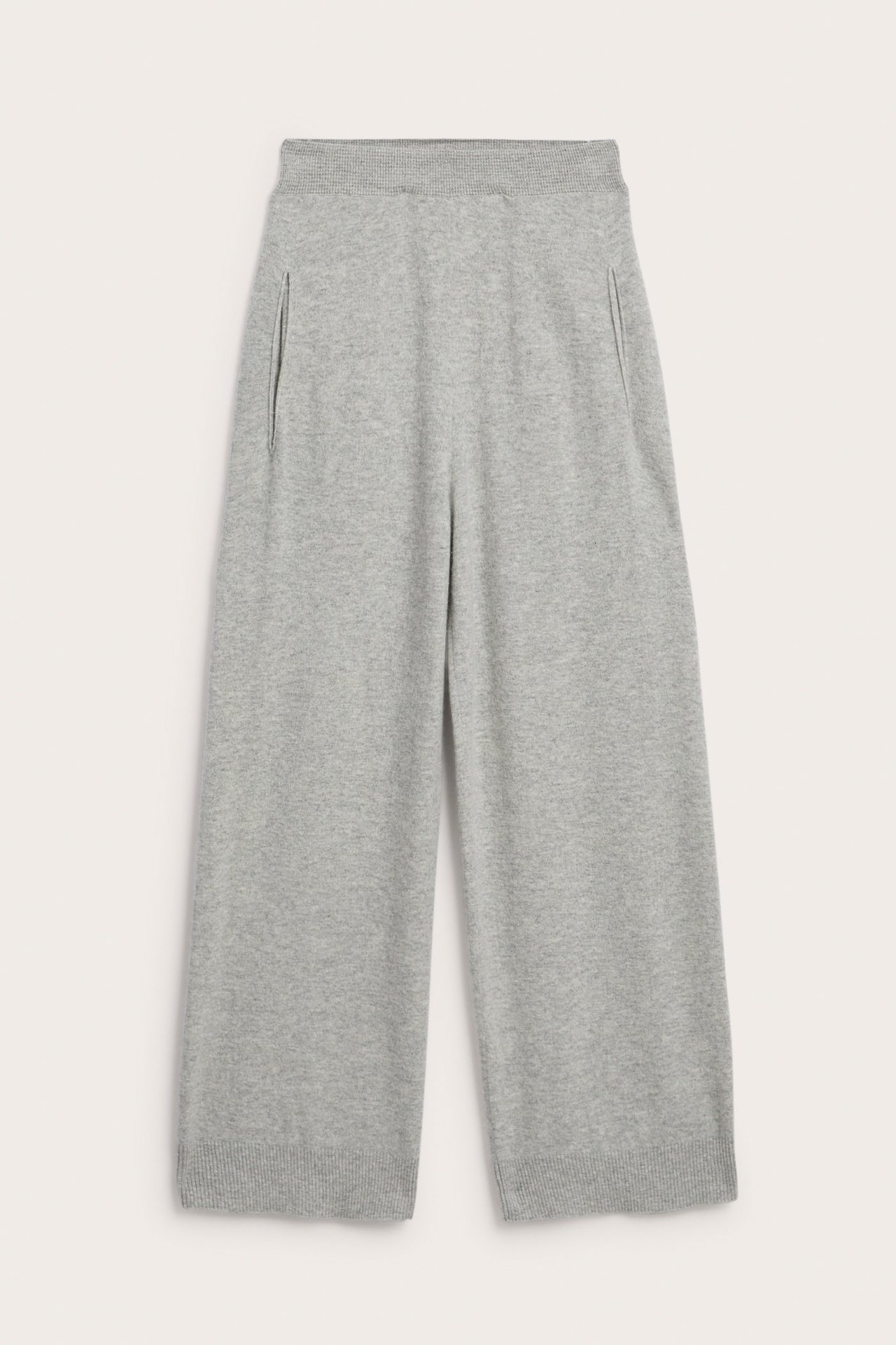 Framifrån, ljusgråmelerade stickade byxor i ull/kashmirblandning med vida ben, ribbad midja och sidfickor.