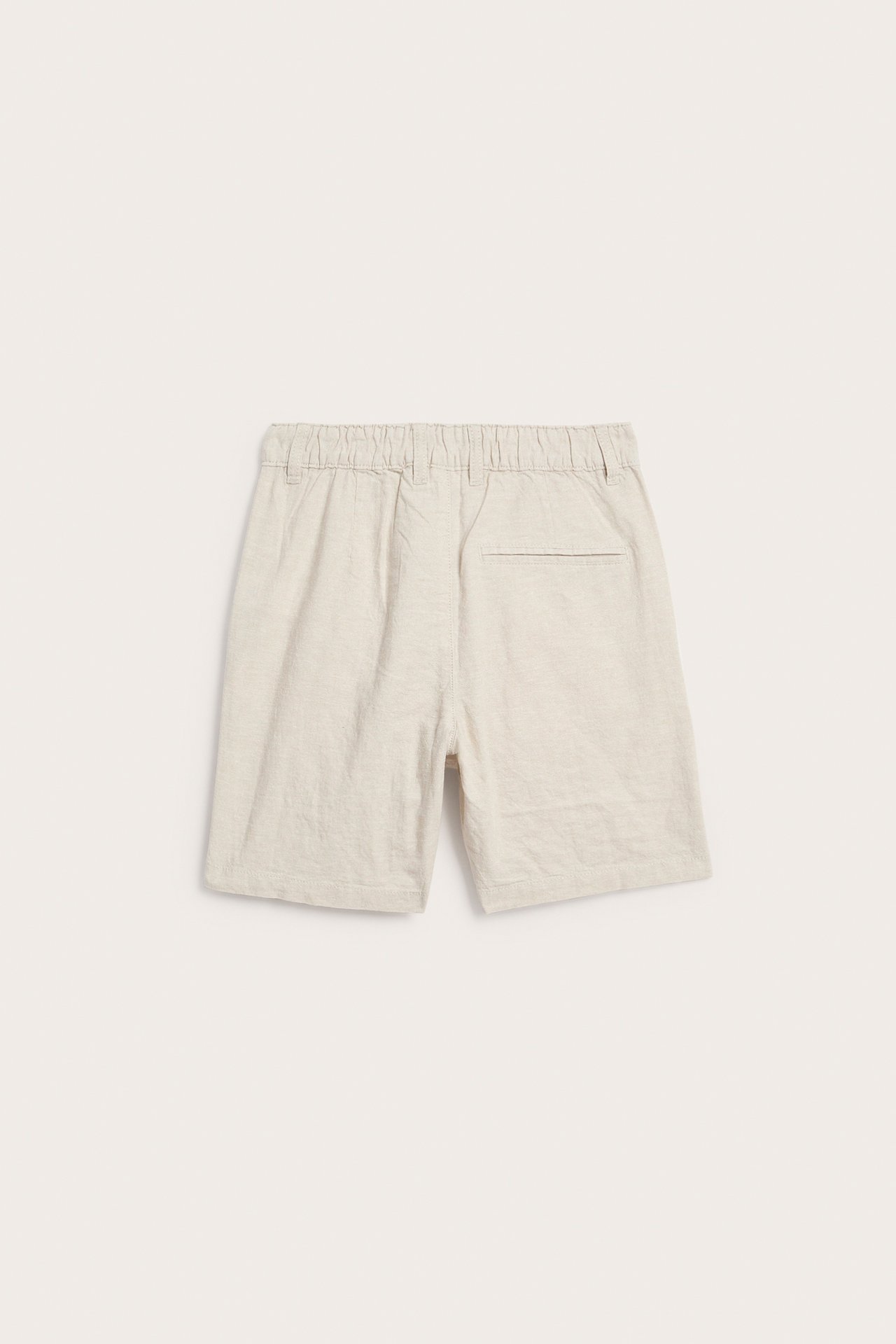 Vaaleanbeiget pellavasekoiteshortsit takaa, joissa on joustava vyötärö ja valetakatasku.