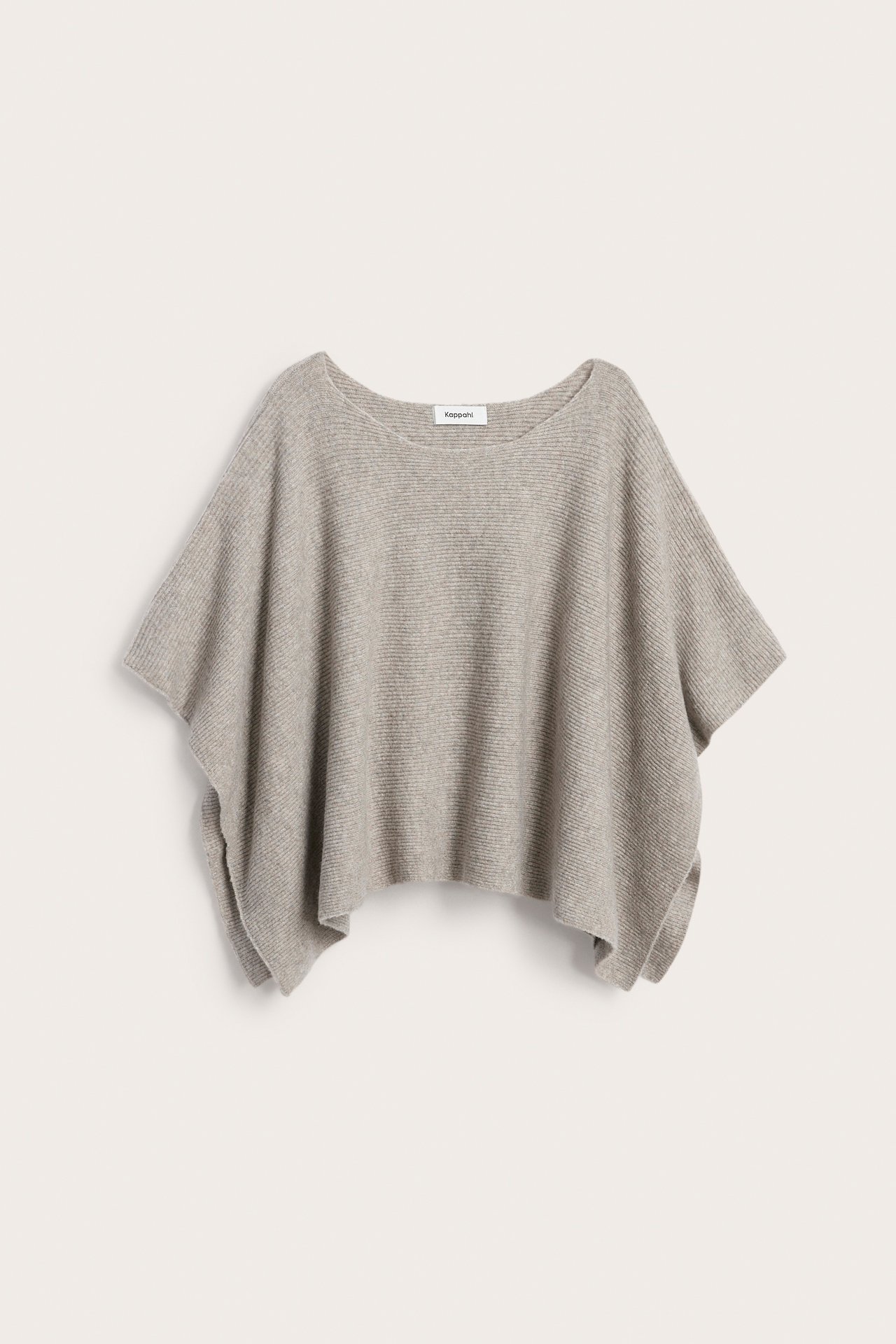 Framifrån, enfärgad stickad poncho i beigemelerad med båthals.