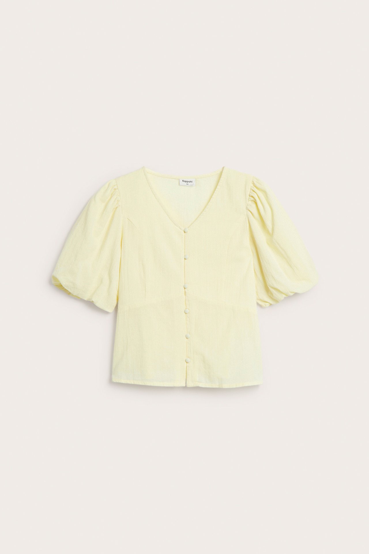 Framifrån, ljusgul barnblus med puffärmar, V-ringning och knäppning framtill.