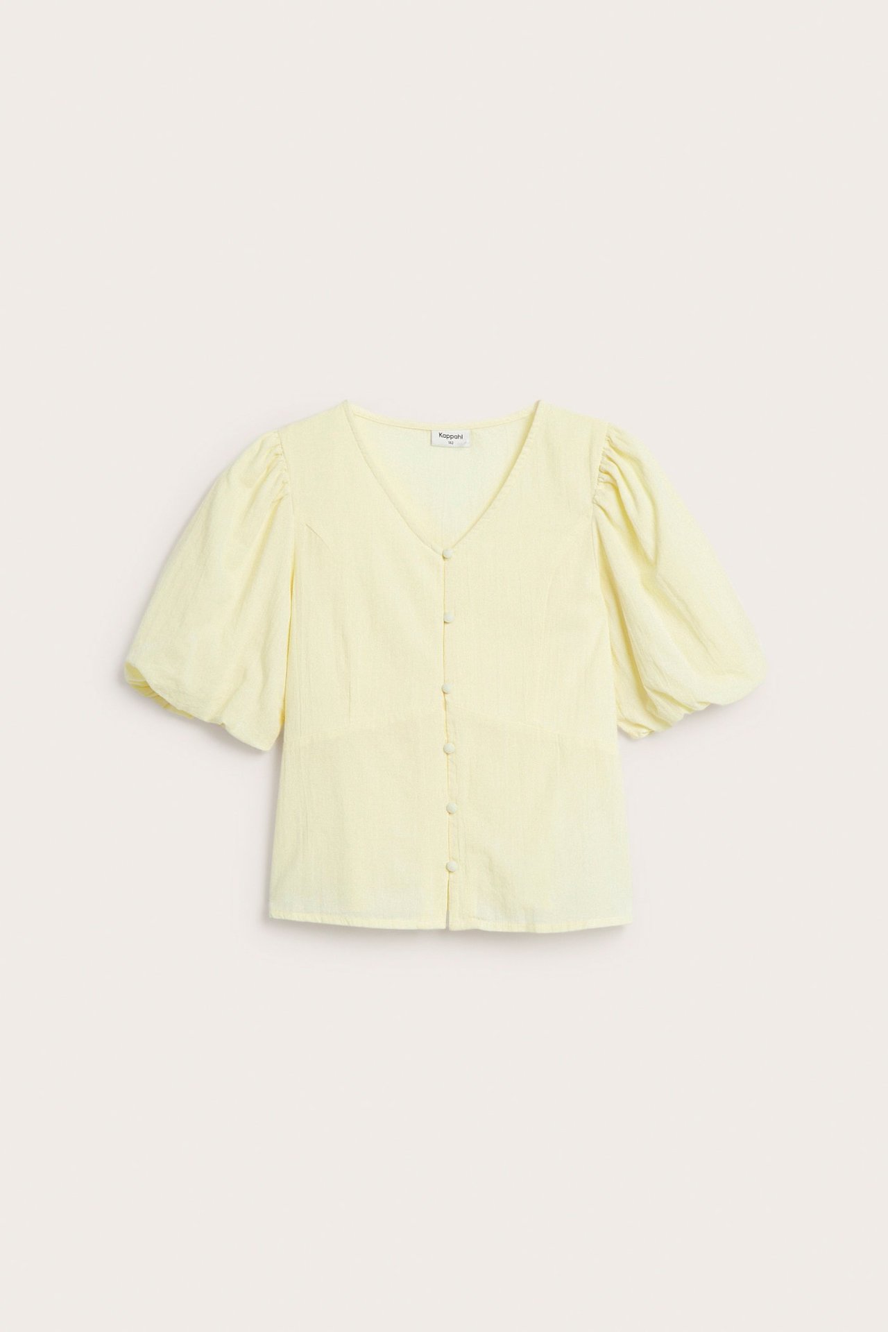 Widok z przodu jasnożółtej bluzki dziecięcej z bufiastymi rękawami, dekoltem w serek i guzikami.