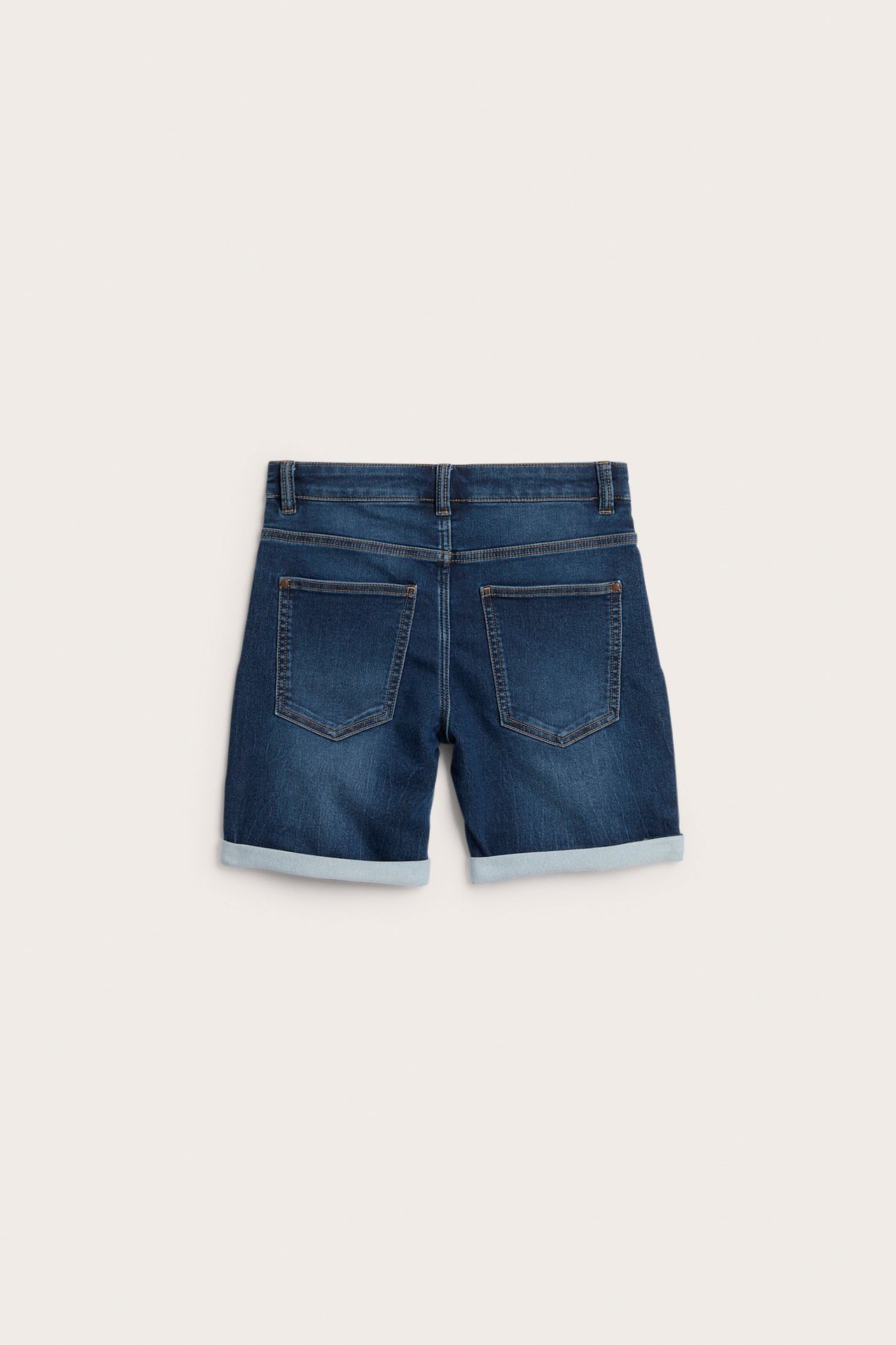 Bakifrån: mörkblå denimshorts med uppvikta benslut och två bakfickor.