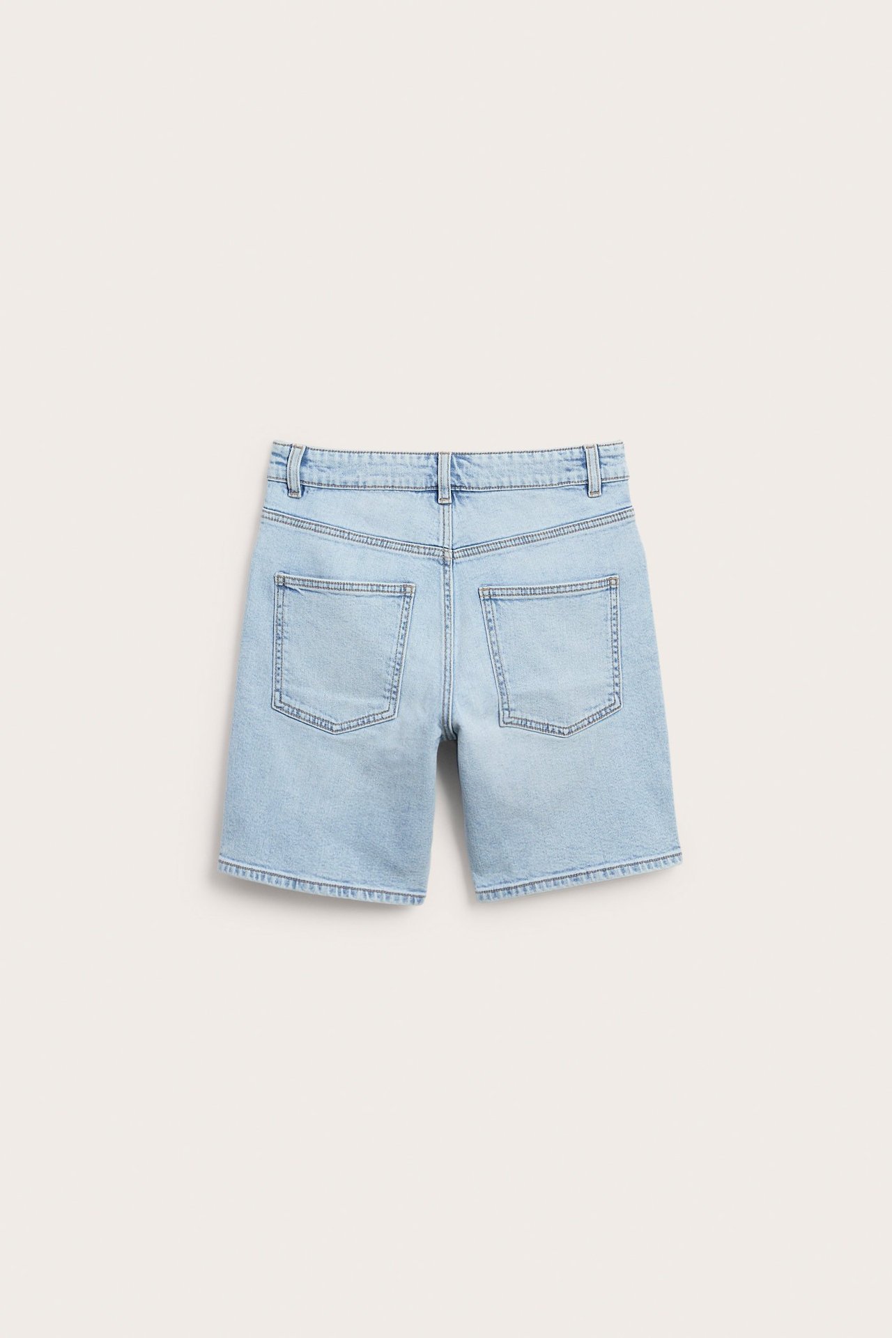 Bakfra av lyseblå, stretchy denimshorts for barn med to baklommer.