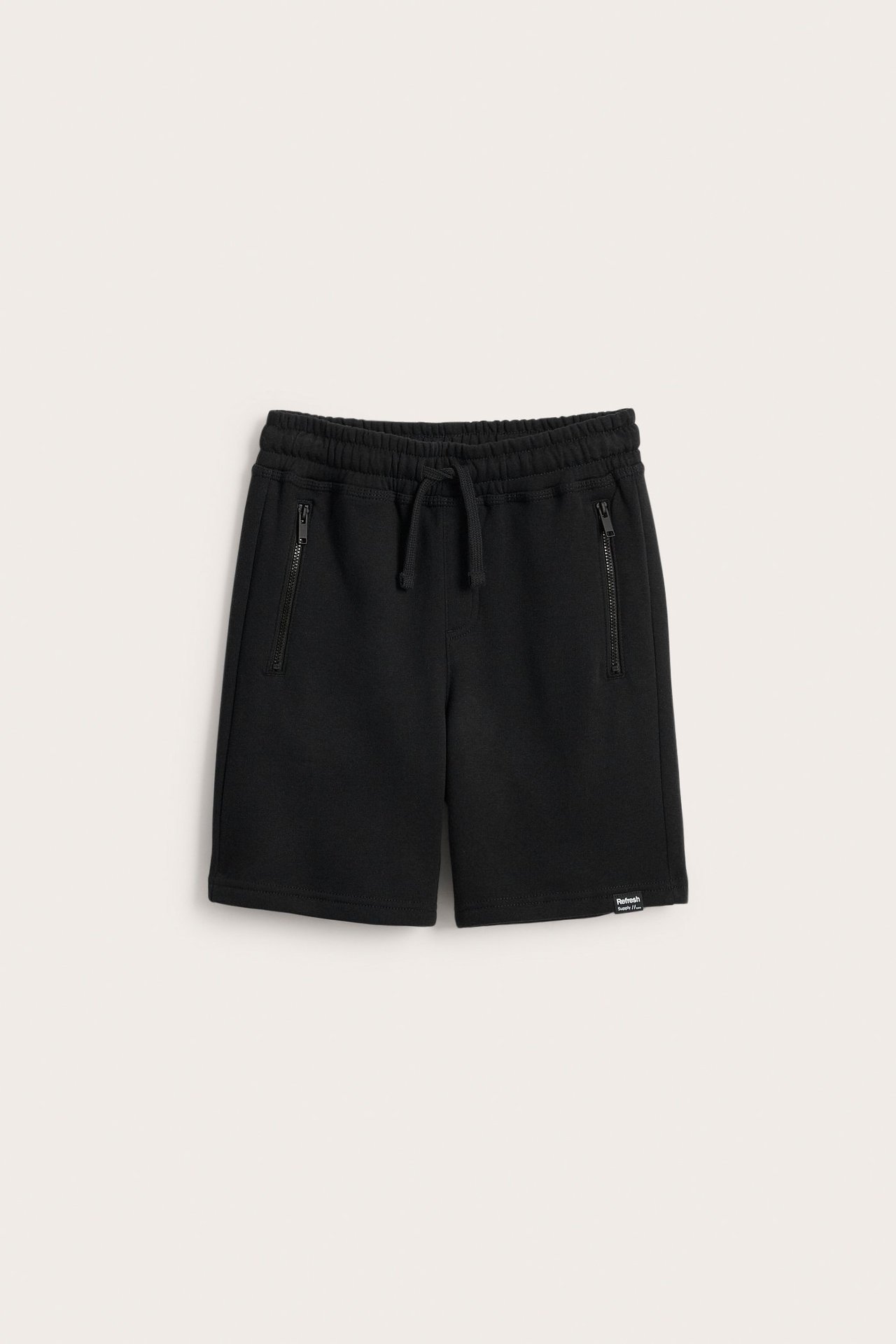 Edestäpäin mustat puuvillatrikooshortsit, joissa nyörivyötärö ja kaksi vetoketjullista taskua.