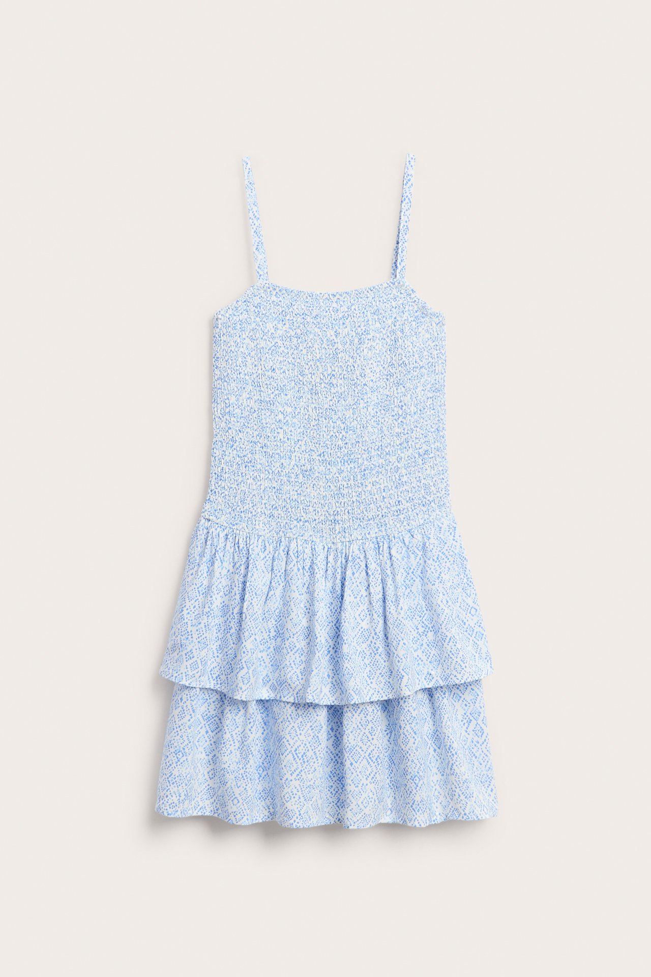 Widok z przodu: Biała krótka sukienka z jasnoniebieskim wzorem, marszczona góra, cienkie ramiączka, falbaniasta spódnica.